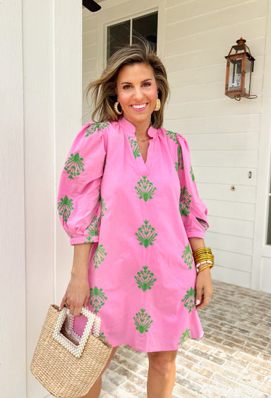Fresh, feminine, and ready for sunny days, this pink dress is giving all the spring garden vibes. The green embroidered floral print pops beautifully against the soft pink background, creating the prettiest contrast that feels bright, cheerful, and effortlessly polished. Designed with a flattering v-neckline and 3/4 length puff sleeves, this dress has just the right amount of structure while still feeling easy and breathable.