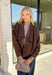 Elevate your layering game with this effortlessly chic faux suede jacket from Entro. Designed in a rich brown hue, this open-front jacket features a beautifully draped lapel that creates an elegant, flattering silhouette. The soft faux suede texture gives it a luxurious feel, while the comfortable stretch fabric makes it easy to wear from morning to night. Whether layered over dresses, blouses, or your favorite sweater, this timeless jacket is the perfect finishing touch for all your fall outfits.