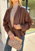 Elevate your layering game with this effortlessly chic faux suede jacket from Entro. Designed in a rich brown hue, this open-front jacket features a beautifully draped lapel that creates an elegant, flattering silhouette. The soft faux suede texture gives it a luxurious feel, while the comfortable stretch fabric makes it easy to wear from morning to night. Whether layered over dresses, blouses, or your favorite sweater, this timeless jacket is the perfect finishing touch for all your fall outfits.