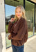 Elevate your layering game with this effortlessly chic faux suede jacket from Entro. Designed in a rich brown hue, this open-front jacket features a beautifully draped lapel that creates an elegant, flattering silhouette. The soft faux suede texture gives it a luxurious feel, while the comfortable stretch fabric makes it easy to wear from morning to night. Whether layered over dresses, blouses, or your favorite sweater, this timeless jacket is the perfect finishing touch for all your fall outfits.