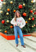 Add a playful pop of holiday cheer to your winter wardrobe with this cozy off-white sweater by Main Strip! Featuring “Fa La La La” embroidered across the front in colorful letters—each with its own fun print—this soft knit is full of festive spirit. Perfect for holiday parties, casual days, or cozy nights in, it’s the kind of merry piece you’ll wear all season long.