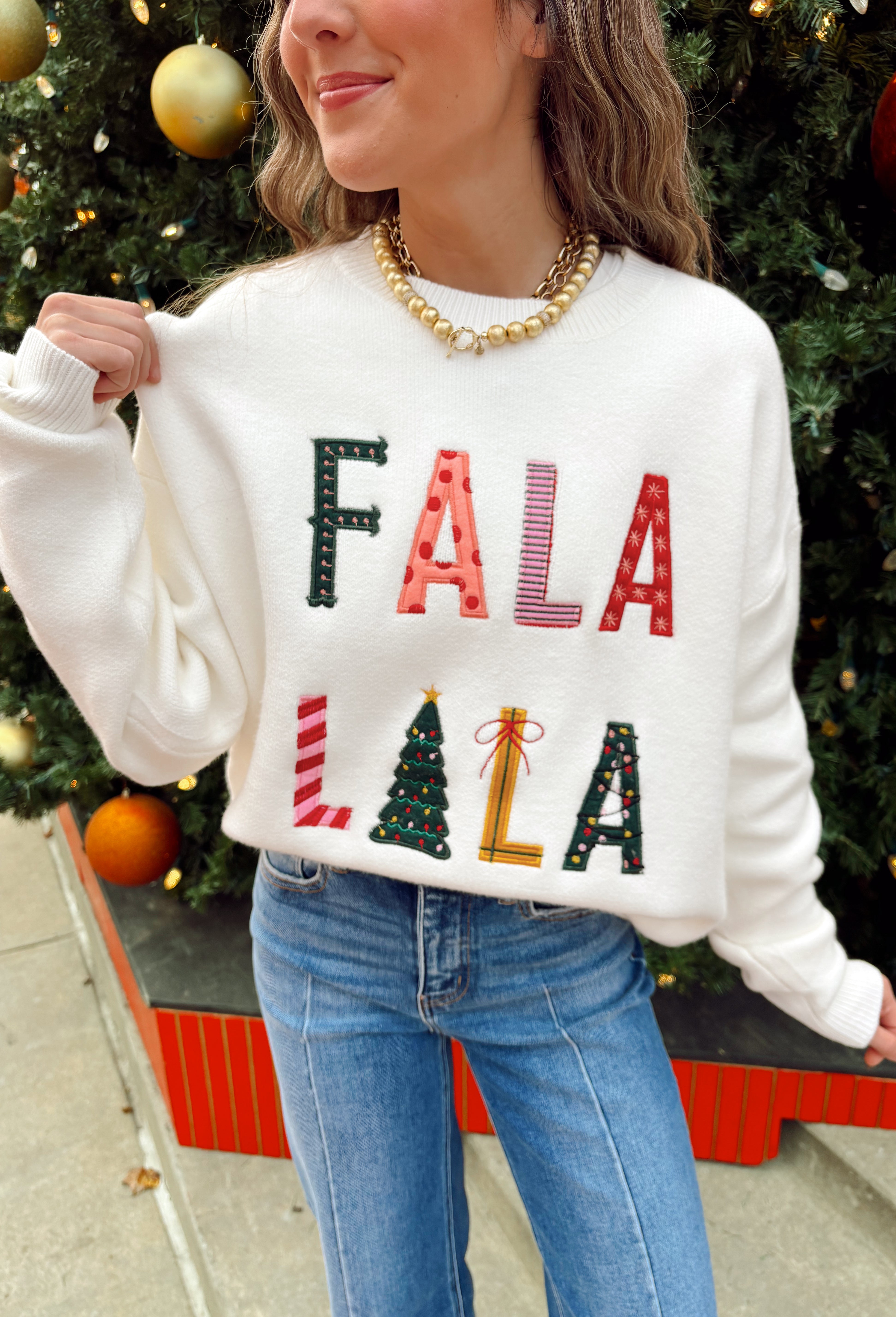 Add a playful pop of holiday cheer to your winter wardrobe with this cozy off-white sweater by Main Strip! Featuring “Fa La La La” embroidered across the front in colorful letters—each with its own fun print—this soft knit is full of festive spirit. Perfect for holiday parties, casual days, or cozy nights in, it’s the kind of merry piece you’ll wear all season long.