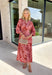 Bring effortless elegance to your fall wardrobe with this beautifully patterned midi dress from Entro. Featuring a soft light pink backdrop with a rich brown geometric print, this timeless dress offers a unique blend of feminine charm and modern style. The flattering v-neckline and removable matching belt create a customizable silhouette, while the long balloon sleeves with button cuffs add graceful movement and sophistication. 