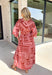 Bring effortless elegance to your fall wardrobe with this beautifully patterned midi dress from Entro. Featuring a soft light pink backdrop with a rich brown geometric print, this timeless dress offers a unique blend of feminine charm and modern style. The flattering v-neckline and removable matching belt create a customizable silhouette, while the long balloon sleeves with button cuffs add graceful movement and sophistication. 