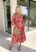 Bring effortless elegance to your fall wardrobe with this beautifully patterned midi dress from Entro. Featuring a soft light pink backdrop with a rich brown geometric print, this timeless dress offers a unique blend of feminine charm and modern style. The flattering v-neckline and removable matching belt create a customizable silhouette, while the long balloon sleeves with button cuffs add graceful movement and sophistication. 