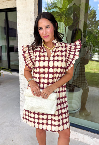 Bring playful charm to your fall wardrobe with this beautiful dress from THML. Designed in a rich burgundy hue with a bold neutral polka dot print, this timeless piece is perfect for everything from brunch dates to seasonal celebrations. The ruffle sleeves are finished with delicate smocking for an extra feminine touch, while the fully lined silhouette offers all-day comfort. Complete with convenient side pockets, this cotton dress is one you'll love reaching for throughout the season.