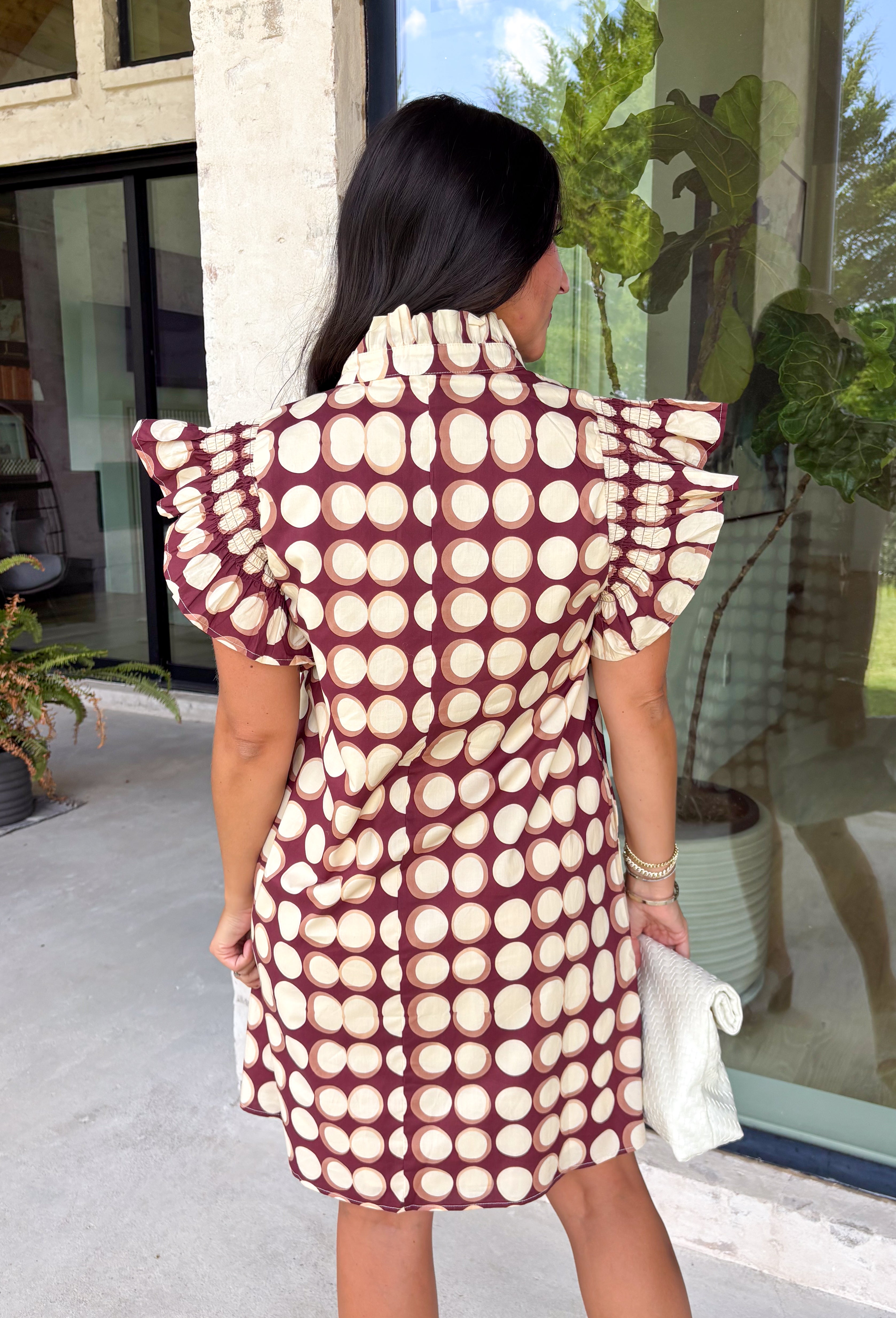 Bring playful charm to your fall wardrobe with this beautiful dress from THML. Designed in a rich burgundy hue with a bold neutral polka dot print, this timeless piece is perfect for everything from brunch dates to seasonal celebrations. The ruffle sleeves are finished with delicate smocking for an extra feminine touch, while the fully lined silhouette offers all-day comfort. Complete with convenient side pockets, this cotton dress is one you'll love reaching for throughout the season.