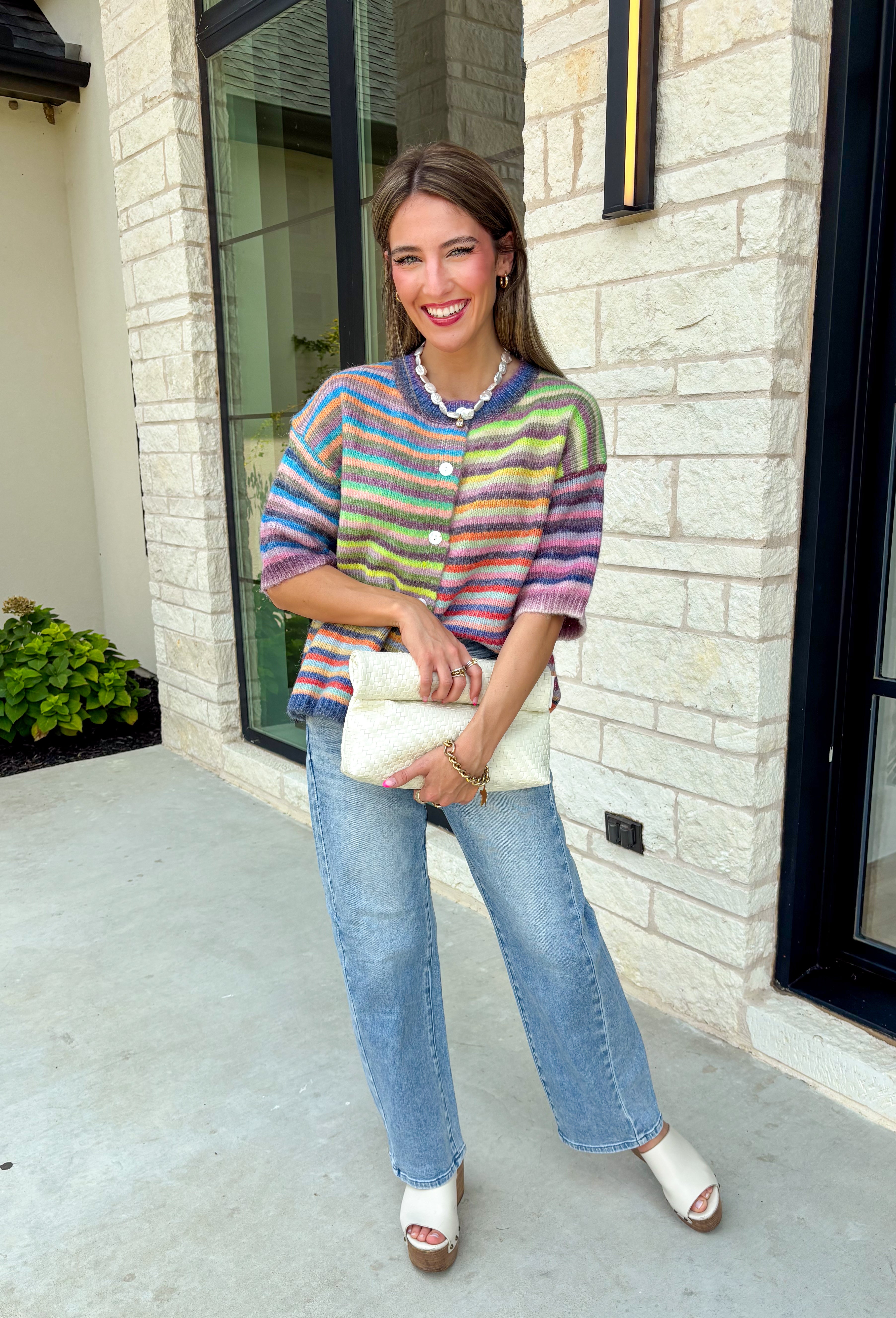 Who says fall has to be all neutrals? This cozy knit cardigan brings a cheerful burst of color to your seasonal wardrobe with bold stripes in green, pink, purple, yellow, blue, and orange. The button-down design gives you endless styling options—wear it buttoned as a sweater or open over your favorite basics for an effortless layered look. Crafted from a soft, cozy knit, it's the perfect piece to brighten crisp autumn days while keeping you comfortable from morning coffee runs to weekend adventures.