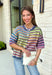 Who says fall has to be all neutrals? This cozy knit cardigan brings a cheerful burst of color to your seasonal wardrobe with bold stripes in green, pink, purple, yellow, blue, and orange. The button-down design gives you endless styling options—wear it buttoned as a sweater or open over your favorite basics for an effortless layered look. Crafted from a soft, cozy knit, it's the perfect piece to brighten crisp autumn days while keeping you comfortable from morning coffee runs to weekend adventures.