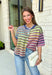 Who says fall has to be all neutrals? This cozy knit cardigan brings a cheerful burst of color to your seasonal wardrobe with bold stripes in green, pink, purple, yellow, blue, and orange. The button-down design gives you endless styling options—wear it buttoned as a sweater or open over your favorite basics for an effortless layered look. Crafted from a soft, cozy knit, it's the perfect piece to brighten crisp autumn days while keeping you comfortable from morning coffee runs to weekend adventures.