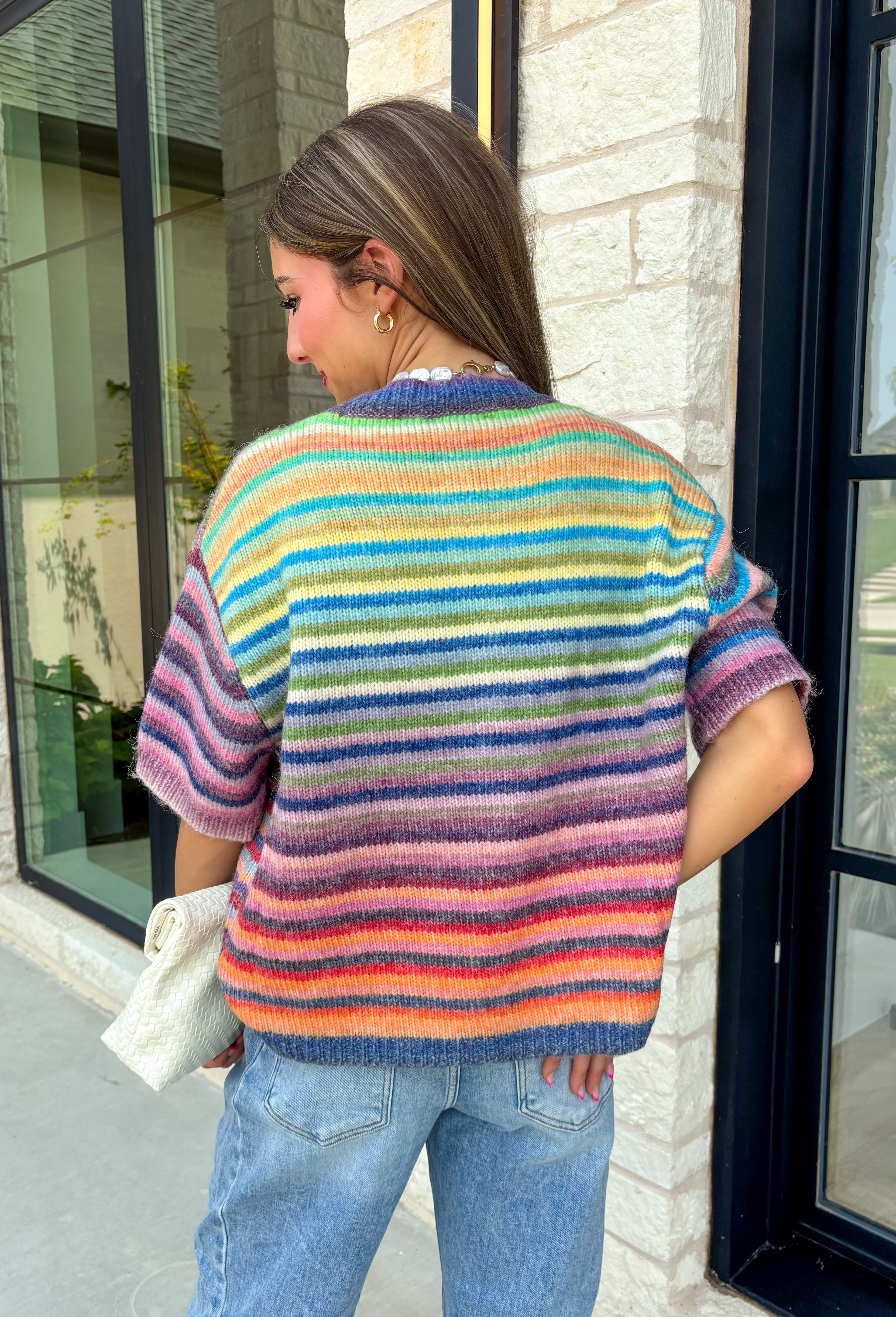Who says fall has to be all neutrals? This cozy knit cardigan brings a cheerful burst of color to your seasonal wardrobe with bold stripes in green, pink, purple, yellow, blue, and orange. The button-down design gives you endless styling options—wear it buttoned as a sweater or open over your favorite basics for an effortless layered look. Crafted from a soft, cozy knit, it's the perfect piece to brighten crisp autumn days while keeping you comfortable from morning coffee runs to weekend adventures.