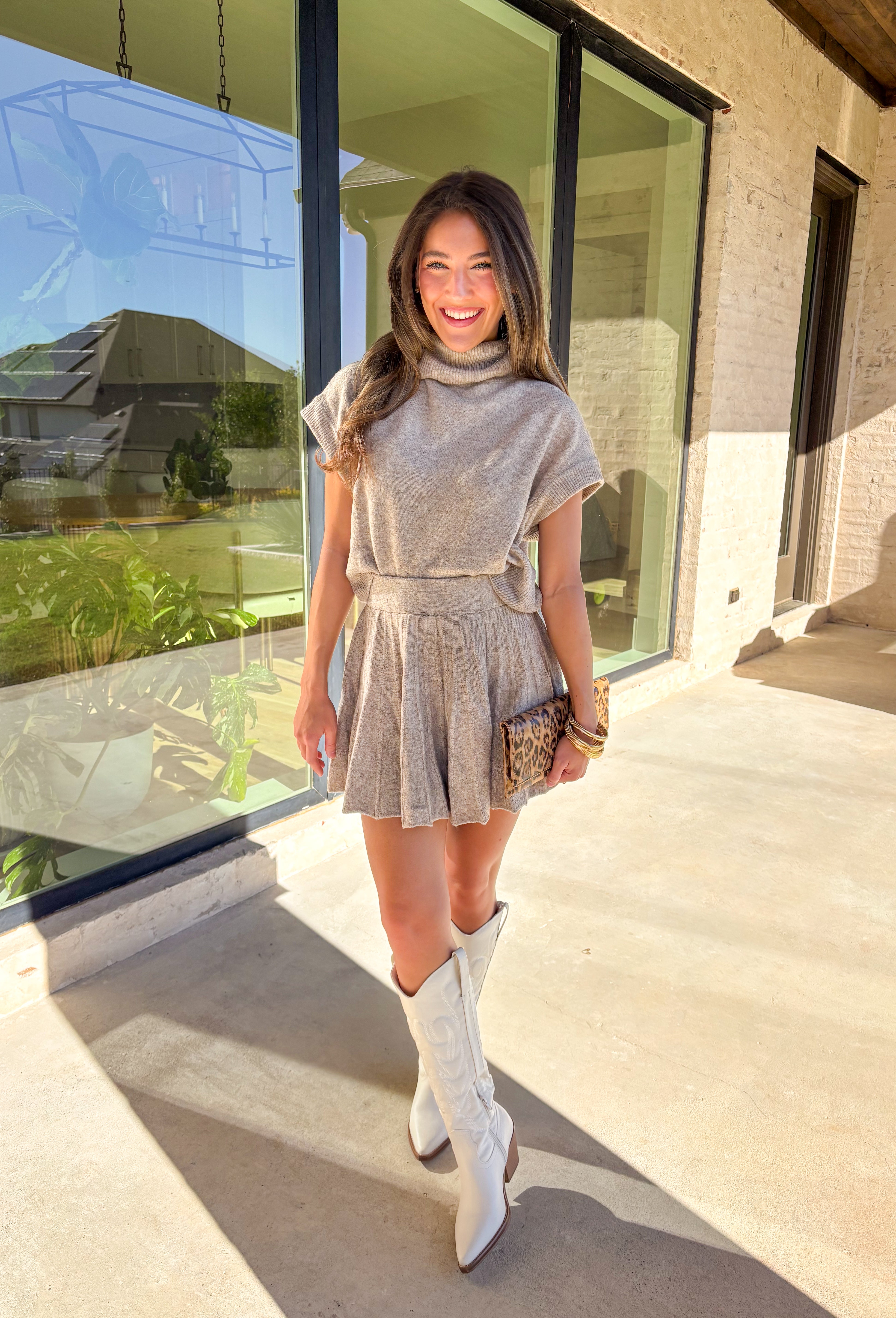 Chic meets cozy in this dark taupe two-piece set by Double Zero. Made from a soft, plush knit, this matching set features a short sleeve turtleneck sweater paired with a pleated skirt for an effortlessly put-together look. Whether you’re heading to brunch, the office, or a holiday gathering, this set gives you comfort and polish all in one.