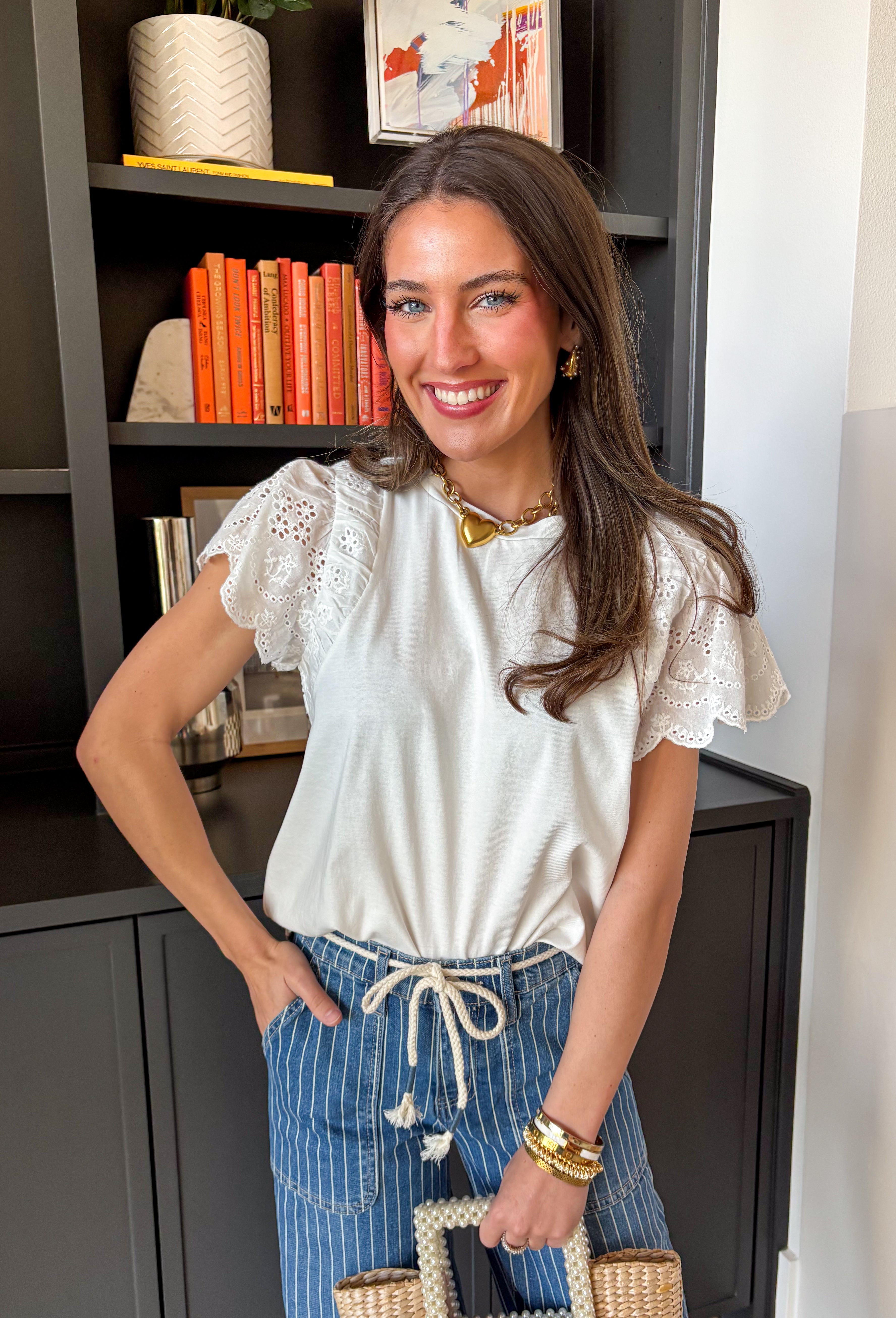 Your favorite everyday white tee just got the prettiest little upgrade. This white short sleeve top by Doe and Rae features delicate eyelet sleeves that instantly elevate a classic silhouette. It’s the perfect blend of casual comfort and feminine detail — easy enough for daily wear, but polished enough to dress up. Made from breathable 100% cotton, this elevated t-shirt keeps you cool and comfortable all season long. 