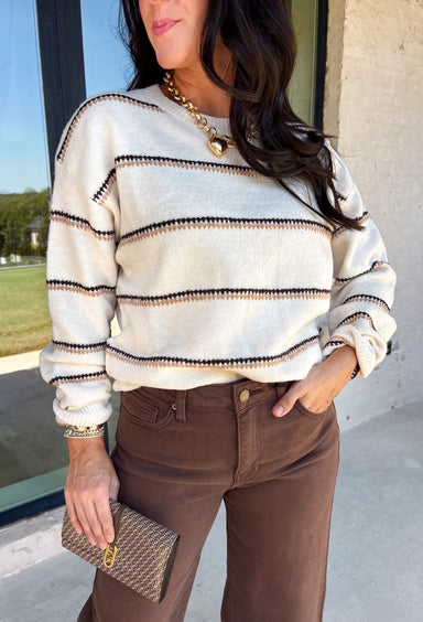 Wrap yourself in cozy comfort with this timeless sweater from Hyfve. Designed in a soft oatmeal knit, this effortlessly stylish sweater features a vintage-inspired stripe pattern in warm shades of tan and brown for the perfect touch of seasonal charm. The relaxed silhouette and soft knit make it an easy piece to throw on for crisp fall days, while the classic design ensures you'll wear it year after year. 