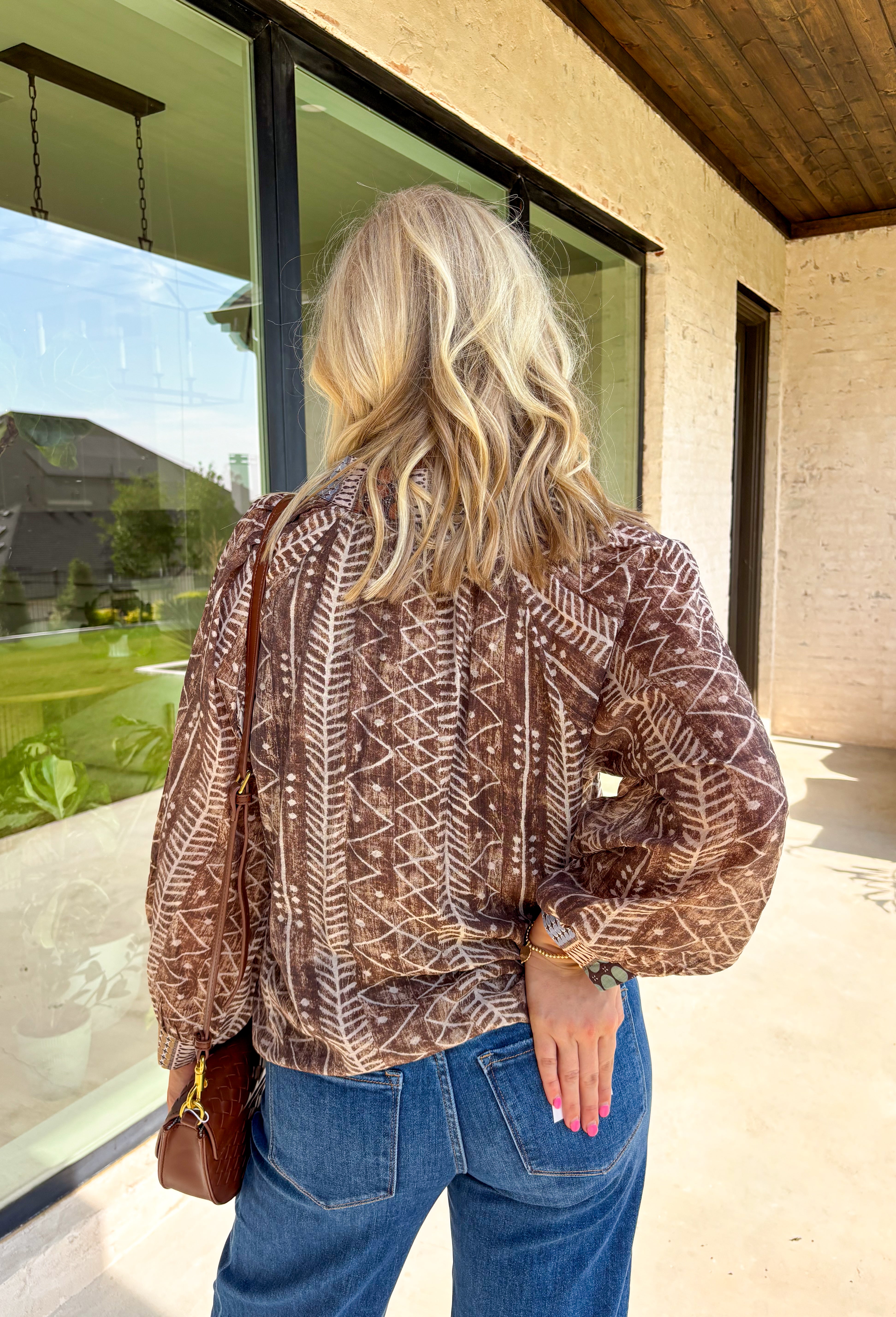 Add some artistic flair to your fall wardrobe with this brown and cream abstract print top. Designed with a contrasting abstract pattern at the neckline and along the front, it’s accented with subtle pops of tan, sage green, and charcoal for a fresh seasonal twist. Lightweight with a soft drape, it’s the kind of blouse that can be styled casually with denim or dressed up for workdays and evenings out.