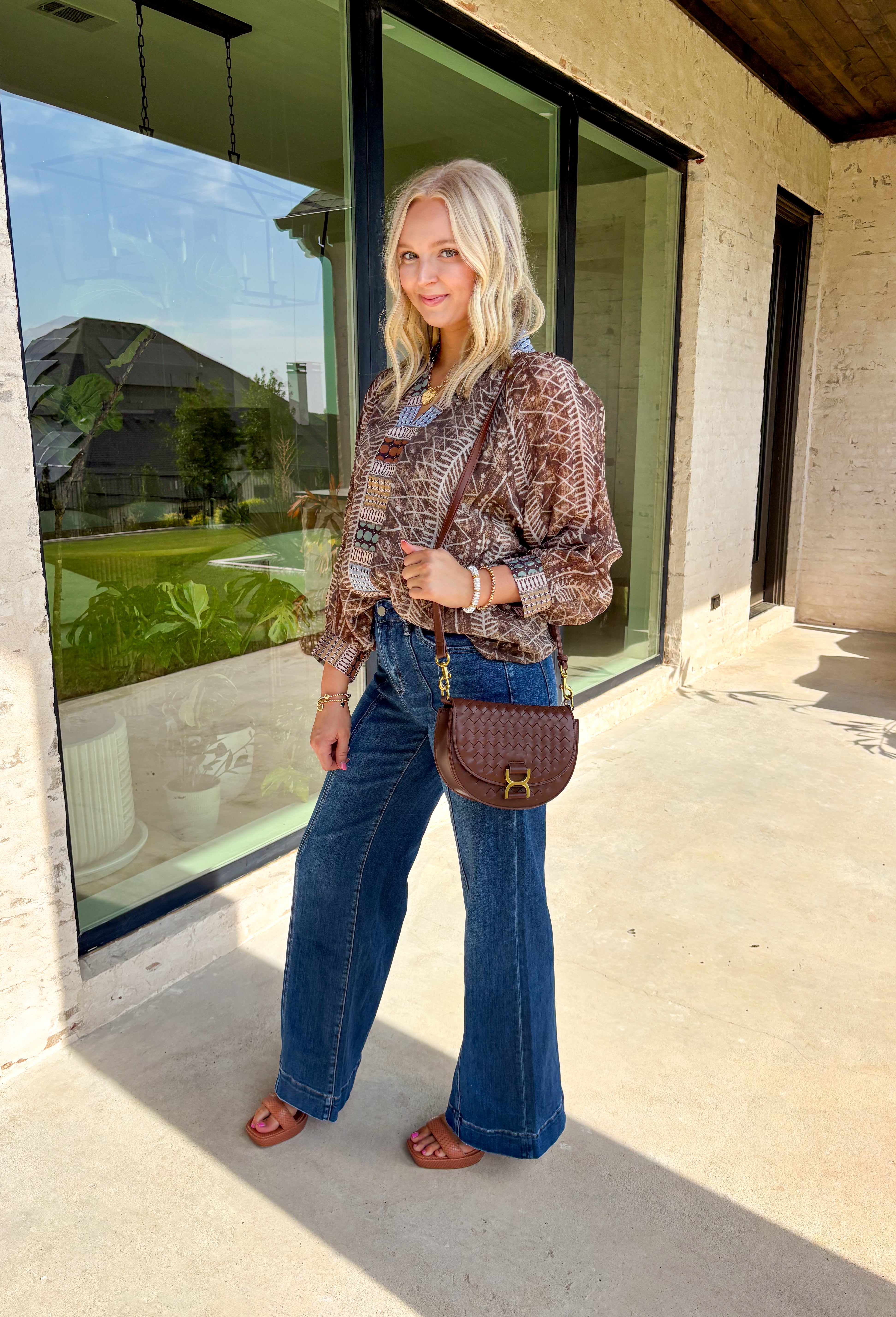 Add some artistic flair to your fall wardrobe with this brown and cream abstract print top. Designed with a contrasting abstract pattern at the neckline and along the front, it’s accented with subtle pops of tan, sage green, and charcoal for a fresh seasonal twist. Lightweight with a soft drape, it’s the kind of blouse that can be styled casually with denim or dressed up for workdays and evenings out.