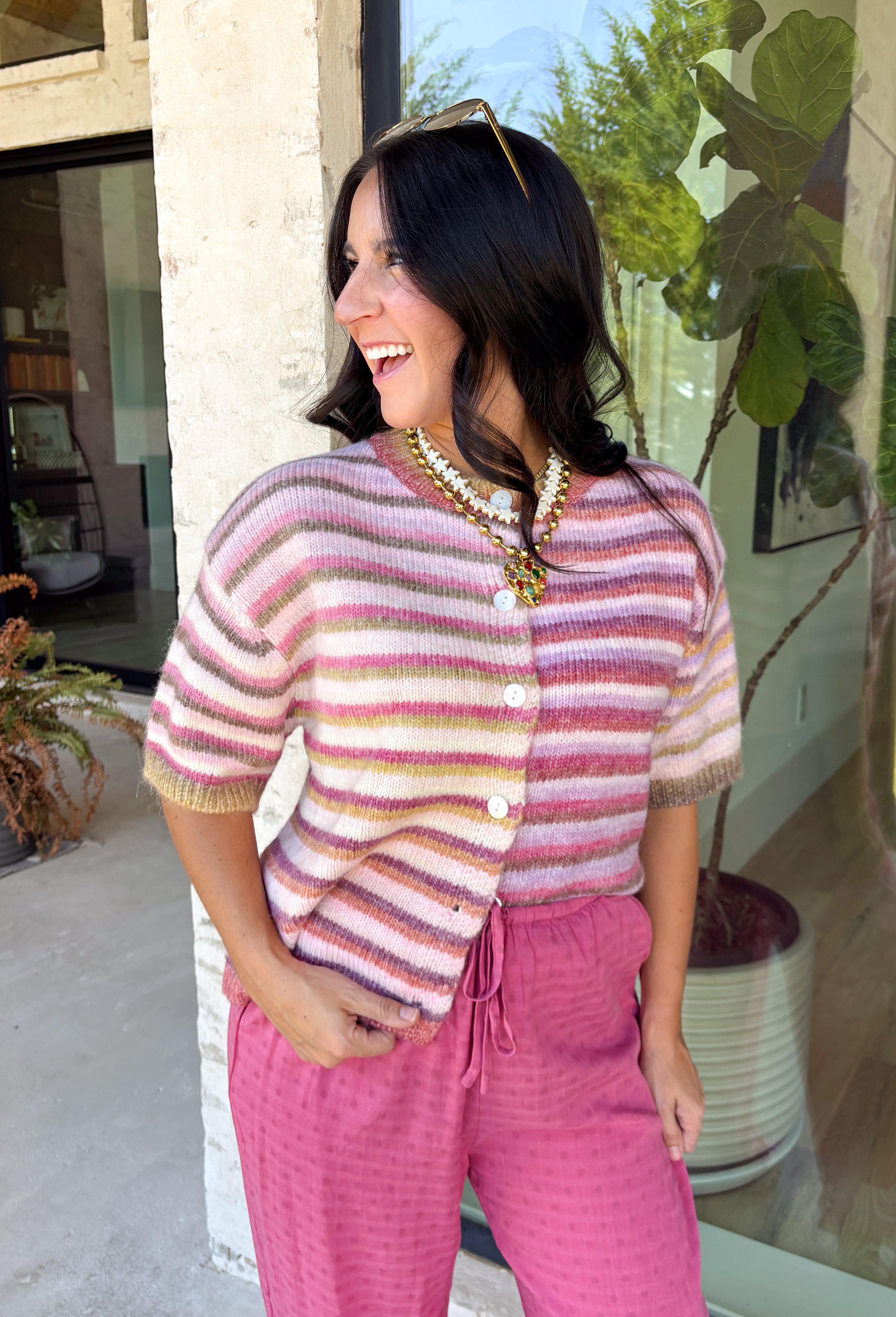 Who says fall has to be all neutrals? This cozy knit cardigan brings a cheerful burst of color to your seasonal wardrobe with bold stripes in shades of berries. The button-down design gives you endless styling options—wear it buttoned as a sweater or open over your favorite basics for an effortless layered look. Crafted from a soft, cozy knit, it's the perfect piece to brighten crisp autumn days while keeping you comfortable from morning coffee runs to weekend adventures.