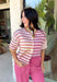 Who says fall has to be all neutrals? This cozy knit cardigan brings a cheerful burst of color to your seasonal wardrobe with bold stripes in shades of berries. The button-down design gives you endless styling options—wear it buttoned as a sweater or open over your favorite basics for an effortless layered look. Crafted from a soft, cozy knit, it's the perfect piece to brighten crisp autumn days while keeping you comfortable from morning coffee runs to weekend adventures.