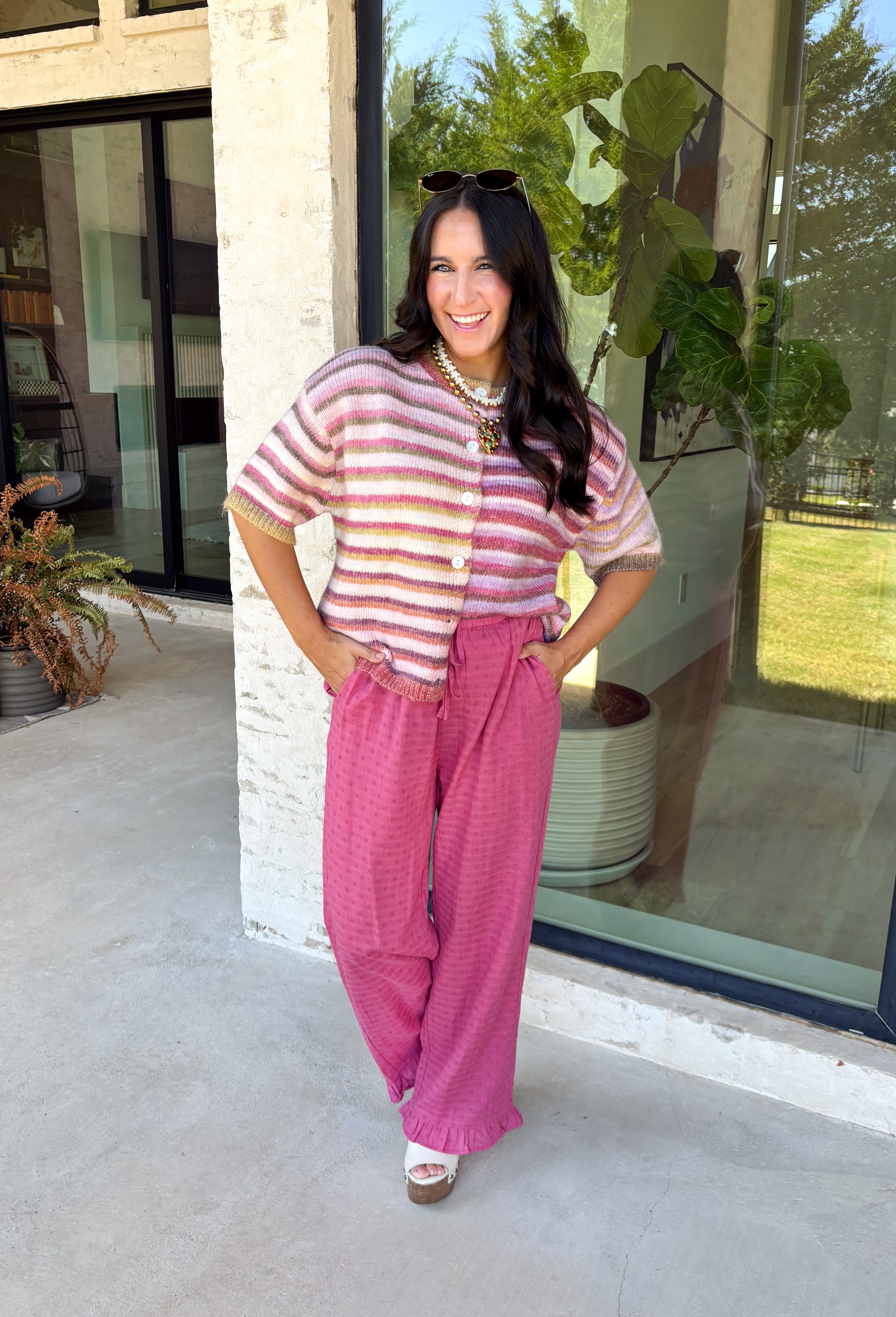Who says fall has to be all neutrals? This cozy knit cardigan brings a cheerful burst of color to your seasonal wardrobe with bold stripes in shades of berries. The button-down design gives you endless styling options—wear it buttoned as a sweater or open over your favorite basics for an effortless layered look. Crafted from a soft, cozy knit, it's the perfect piece to brighten crisp autumn days while keeping you comfortable from morning coffee runs to weekend adventures.
