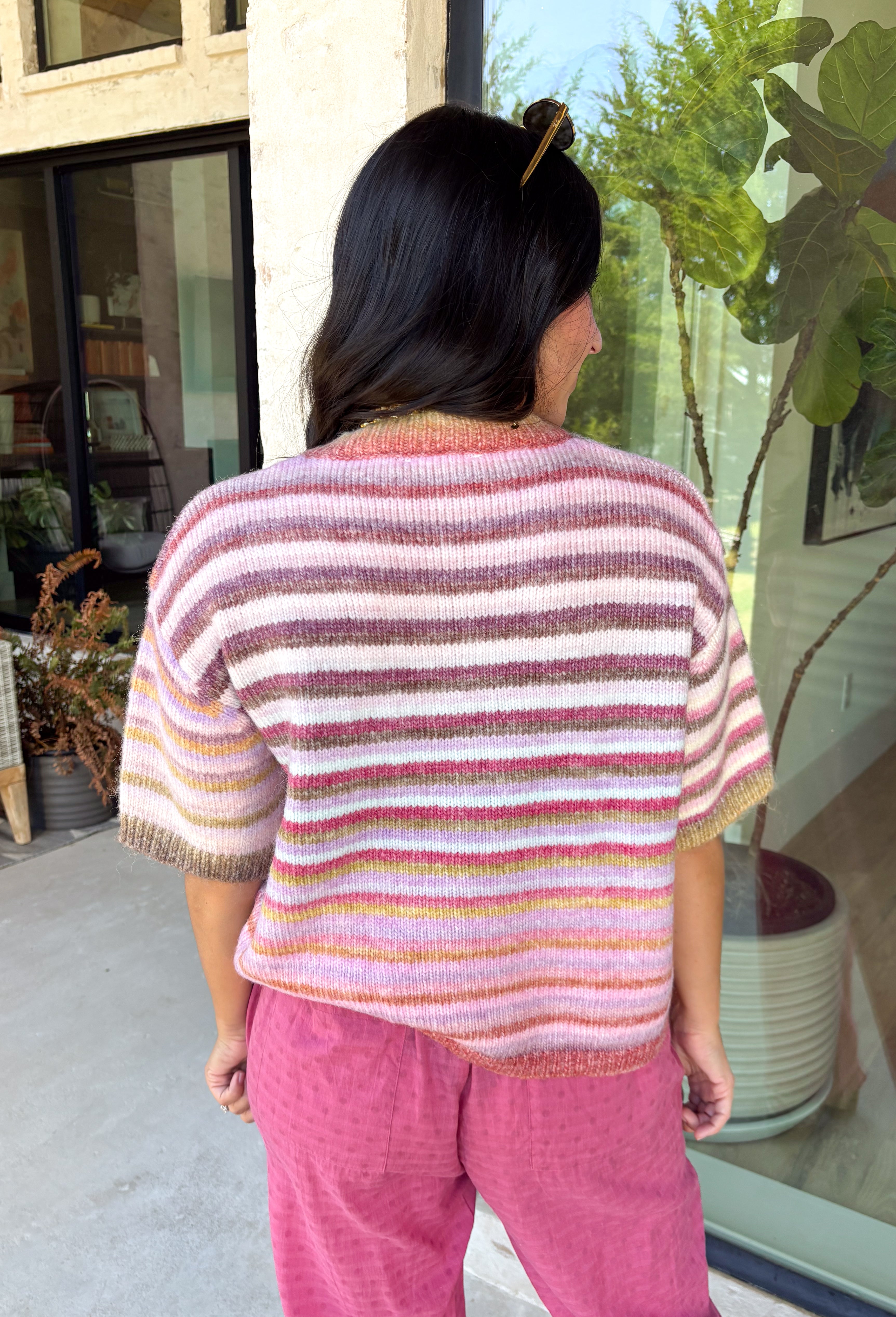 Who says fall has to be all neutrals? This cozy knit cardigan brings a cheerful burst of color to your seasonal wardrobe with bold stripes in shades of berries. The button-down design gives you endless styling options—wear it buttoned as a sweater or open over your favorite basics for an effortless layered look. Crafted from a soft, cozy knit, it's the perfect piece to brighten crisp autumn days while keeping you comfortable from morning coffee runs to weekend adventures.