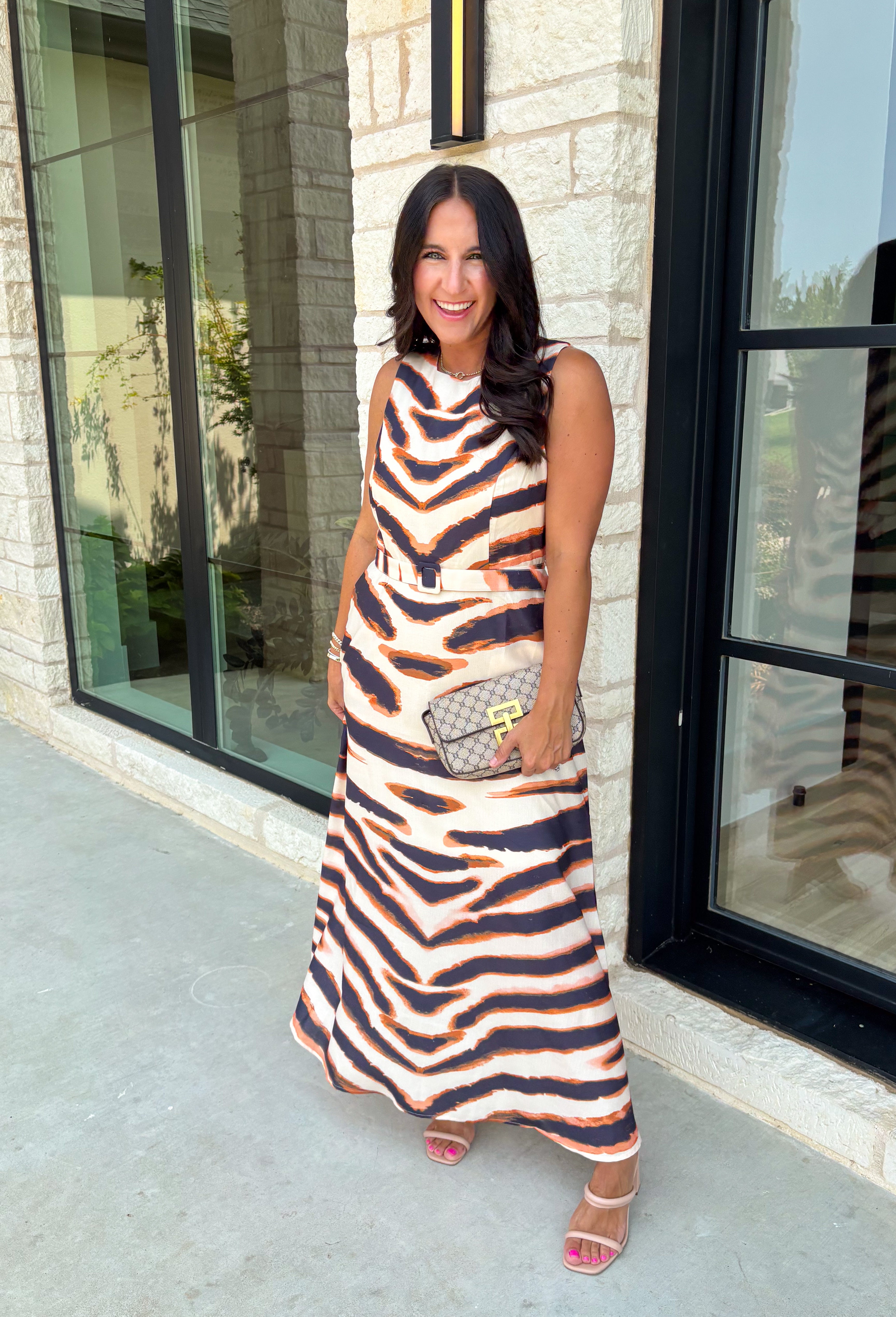 Turn heads this season in a midi dress that's equal parts bold and timeless. Featuring a neutral backdrop with an eye-catching black and orange tiger stripe print, this dress makes a statement while remaining effortlessly wearable. The belted waist creates a flattering silhouette, while side pockets and a fully lined design add comfort and practicality. Whether you're headed to brunch, family photos, or a fall event, this standout dress is ready for every occasion on your calendar.