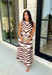 Turn heads this season in a midi dress that's equal parts bold and timeless. Featuring a neutral backdrop with an eye-catching black and orange tiger stripe print, this dress makes a statement while remaining effortlessly wearable. The belted waist creates a flattering silhouette, while side pockets and a fully lined design add comfort and practicality. Whether you're headed to brunch, family photos, or a fall event, this standout dress is ready for every occasion on your calendar.