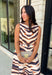 Turn heads this season in a midi dress that's equal parts bold and timeless. Featuring a neutral backdrop with an eye-catching black and orange tiger stripe print, this dress makes a statement while remaining effortlessly wearable. The belted waist creates a flattering silhouette, while side pockets and a fully lined design add comfort and practicality. Whether you're headed to brunch, family photos, or a fall event, this standout dress is ready for every occasion on your calendar.