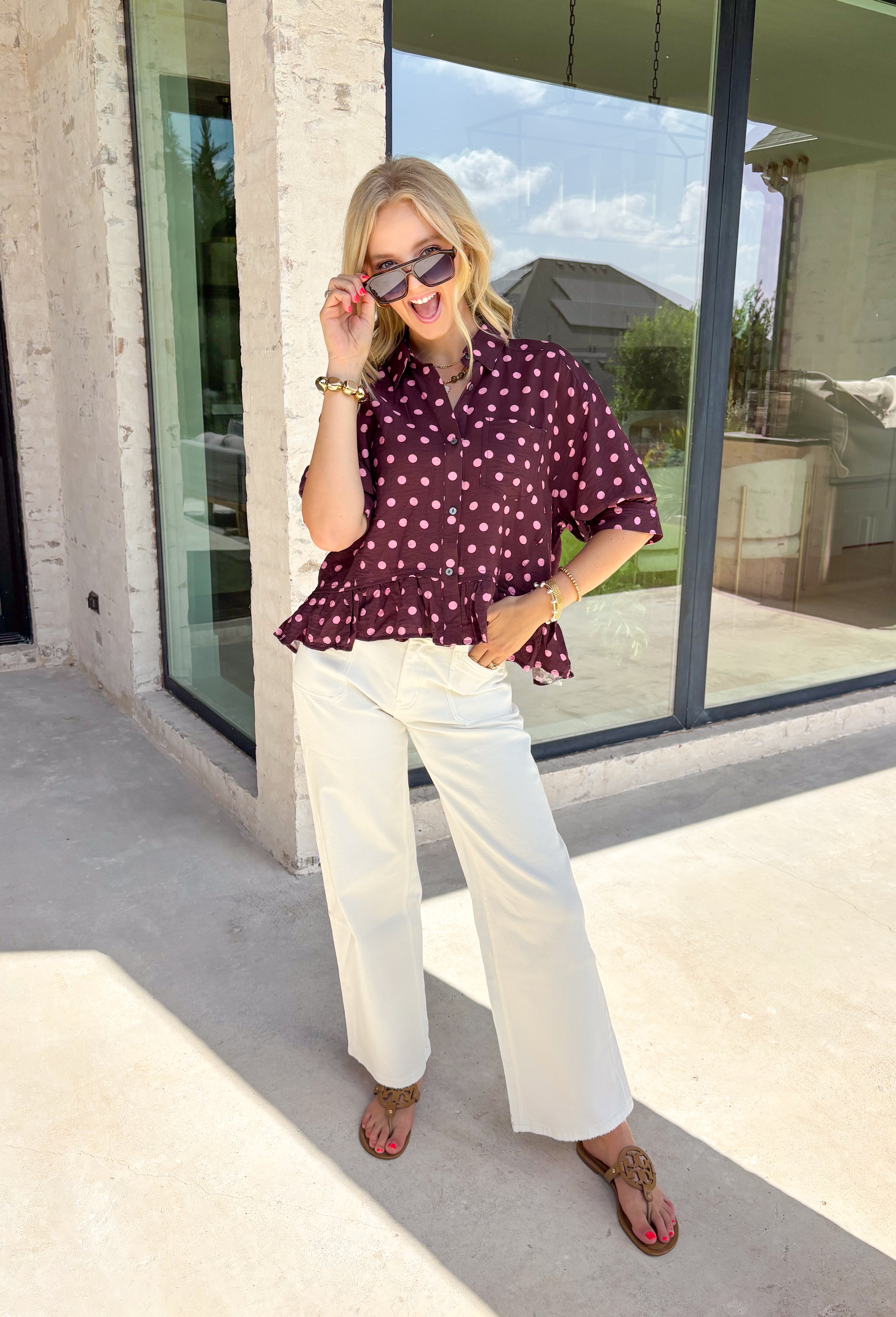 Sweet, playful, and full of feminine charm, this polka dot blouse is the perfect piece to brighten your fall wardrobe. Featuring a rich wine backdrop with pink polka dots, this top blends timeless style with a fun, modern twist. The babydoll silhouette offers an easy, flattering fit, while the ruffle hem and button-front design add beautiful movement and detail.