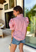 Nothing says sweet spring style quite like red and white stripes paired with cheerful florals. This striped short puff sleeve top by Entro brings playful charm and feminine detail together in the prettiest way. The classic red and white stripe base is brightened up with pink, red, green, and blue floral embroidery that adds texture, color, and that extra-special touch. Designed with a flattering button-front closure and soft puff sleeves, this top feels polished yet easy to wear. 