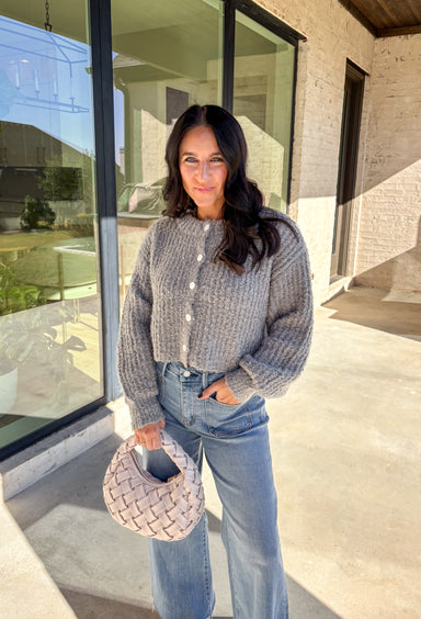 Soft, cozy, and perfectly cropped—this heather gray cardigan by Double Zero is a closet must-have for the season. The button-down front and relaxed fit make it effortlessly versatile, while the ultra-soft fabric keeps it comfy for all-day wear. Ideal for layering over your favorite tanks or pairing with high-rise denim, this cozy cutie is ready for fall days and nights in.