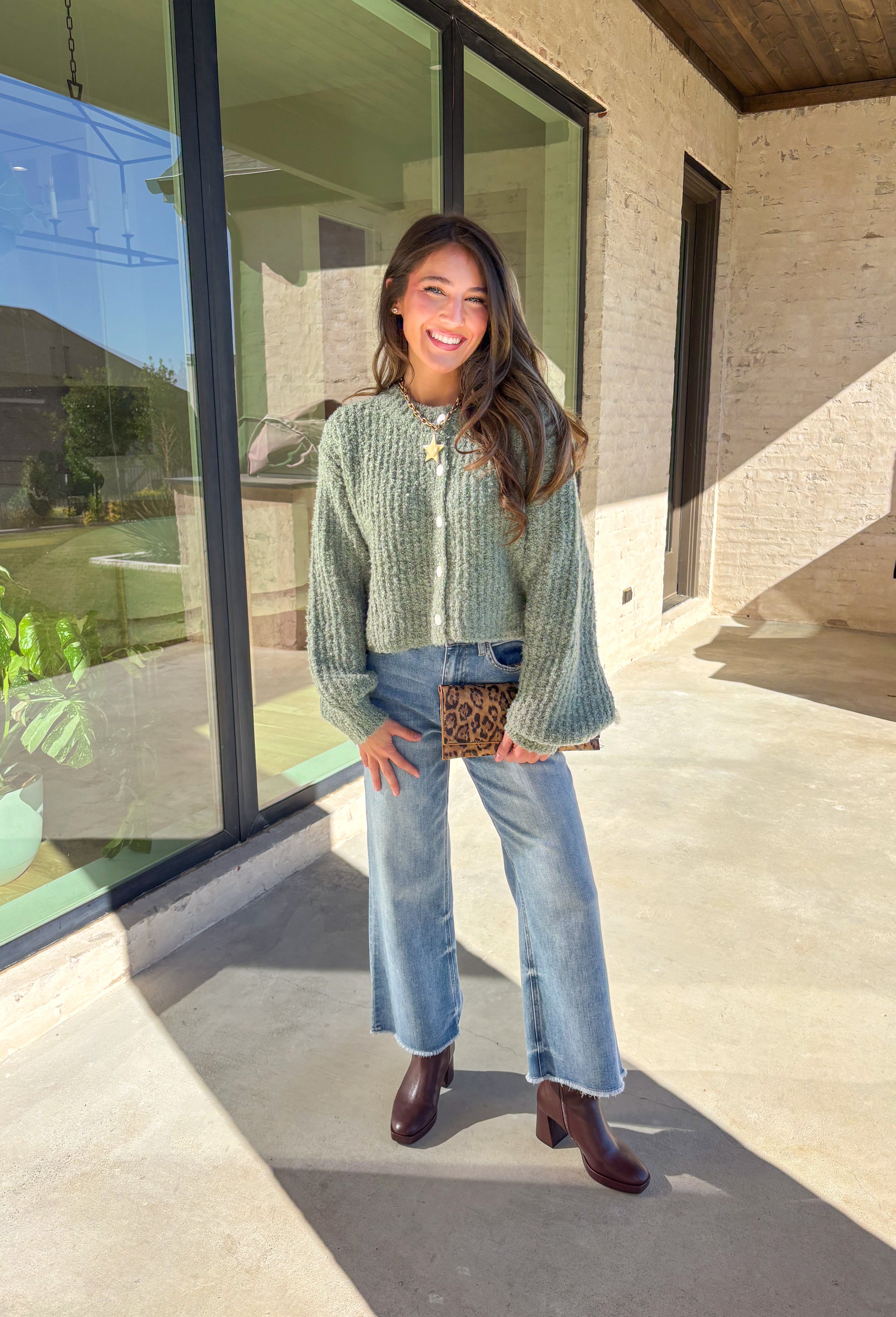 Soft, cozy, and perfectly cropped—this sage green cardigan by Double Zero is a closet must-have for the season. The button-down front and relaxed fit make it effortlessly versatile, while the ultra-soft fabric keeps it comfy for all-day wear. Ideal for layering over your favorite tanks or pairing with high-rise denim, this cozy cutie is ready for fall days and nights in.