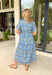 This blue striped midi dress is the perfect blend of classic and cheerful for summer! The blue stripe print creates a timeless foundation, while the yellow floral pattern adds a bright, sunny pop that instantly stands out. Designed with a collared neckline and button front closure, it has a polished feel that's easy to dress up or down. The adjustable drawstring waist creates a flattering silhouette, and side pockets make it even better. 