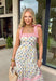 Fresh, colorful, and made for sunny days! This neutral tiered dress features a vibrant floral print with pops of pink, yellow, purple, blue, and green for a cheerful, eye-catching look. The flowy tiered silhouette adds beautiful movement, while the pink and white stripe trim throughout gives it an extra playful touch. The adjustable tie straps not only add a sweet detail but also allow for a customizable fit. Lightweight and fully lined, this dress is perfect for everything.