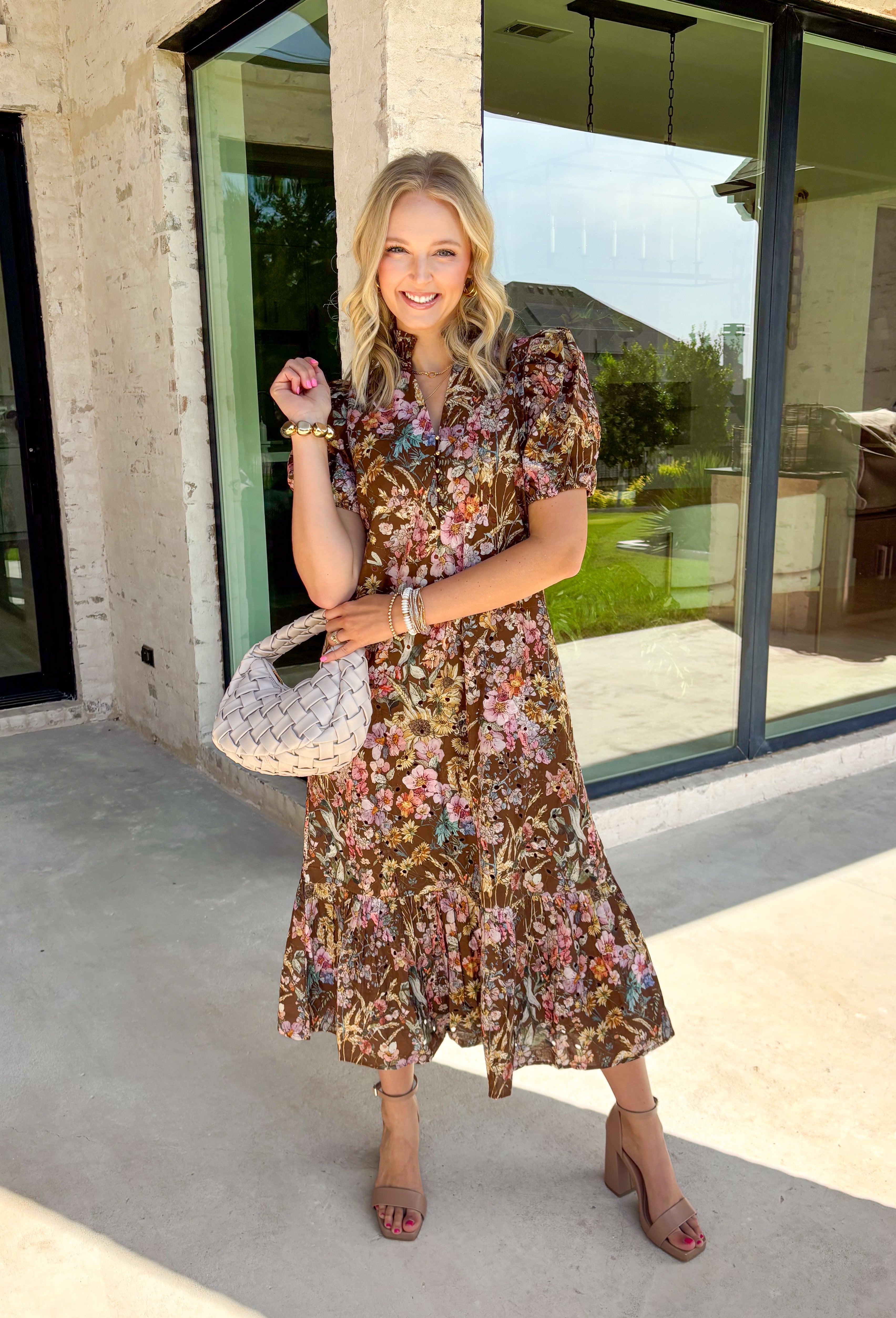 Fall florals have never looked so timeless! This beautiful brown midi dress features a delicate floral print with eyelet detailing that adds texture and charm to every look. The ruffled band collar and flattering v-neckline create an effortlessly feminine silhouette, while the button front brings a classic touch. Finished with short puff sleeves, side pockets, and a fully lined design, this dress is as practical as it is beautiful.