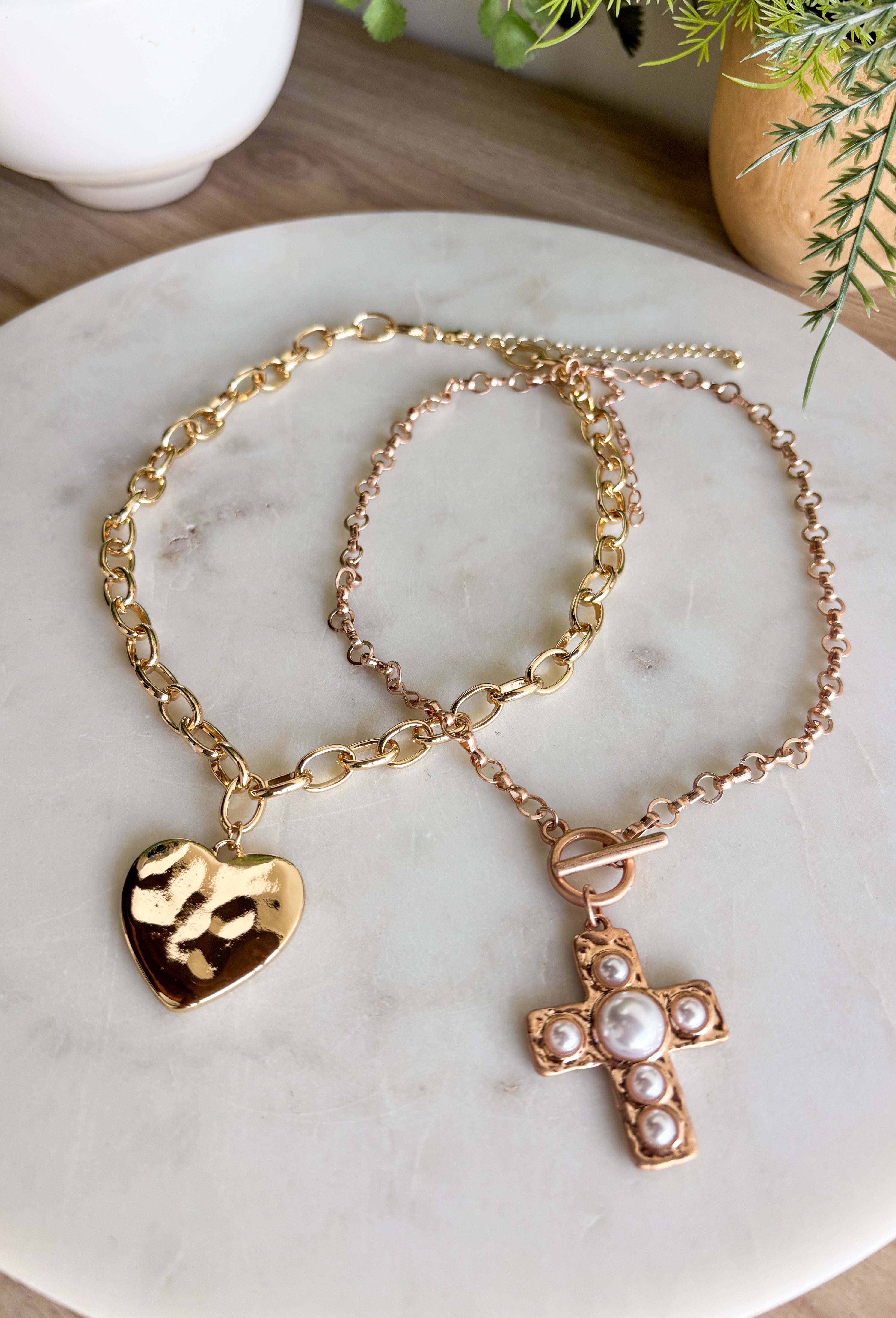 Simple, stylish, and oh-so versatile—this gold chain necklace is the perfect finishing touch for any look. Designed with a textured heart charm, it adds just the right amount of detail and personality without overpowering your outfit. With its adjustable extender, you can wear it closer to the neckline for layering or a little longer on its own. A timeless piece you’ll keep reaching for, no matter the occasion.