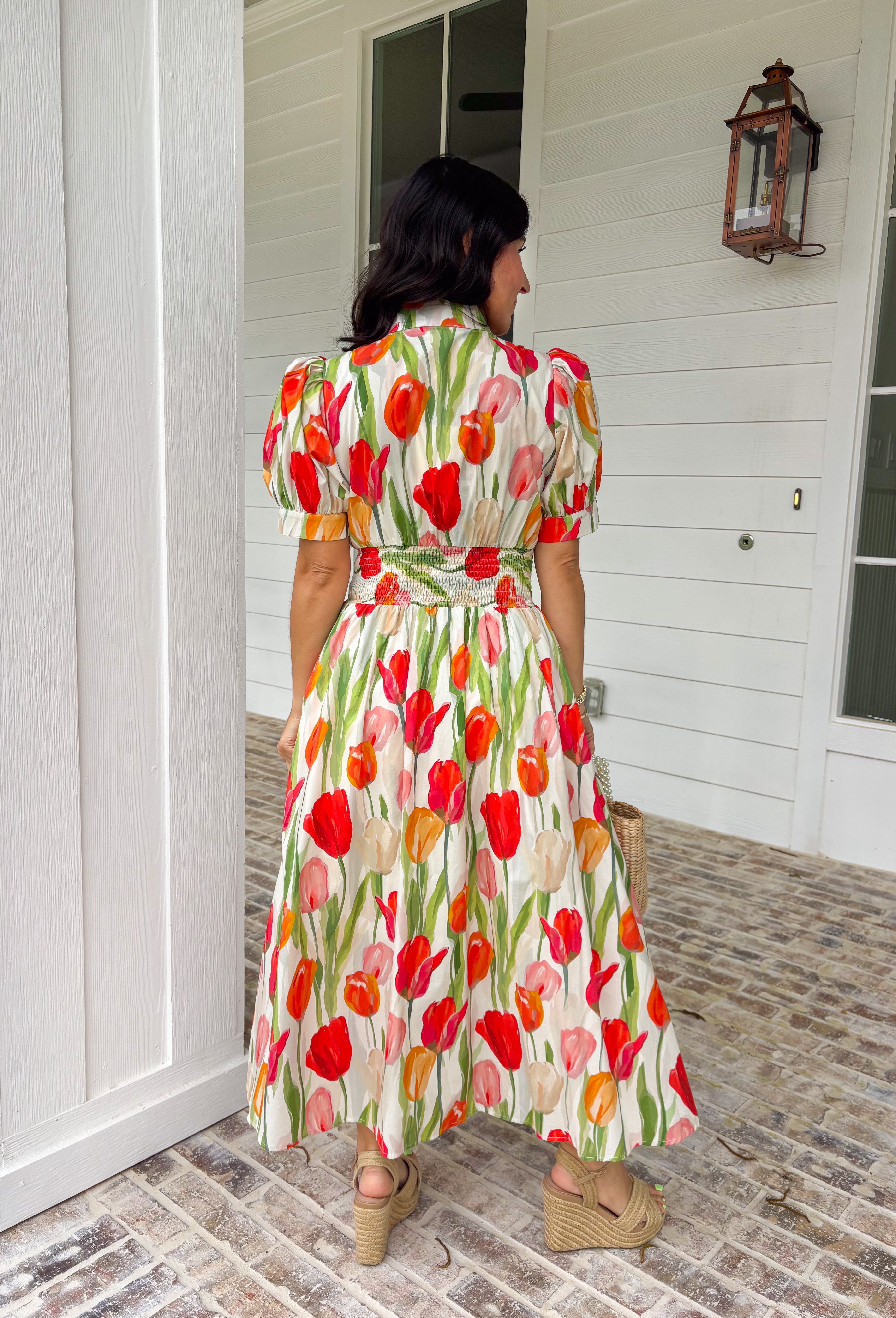 Bright blooms and easy details make this neutral short sleeve midi dress by Entro a spring favorite. Featuring a bold tulip floral print with vibrant pops of red, green, and orange, it brings cheerful color to a soft, wearable base. Puff sleeves add a feminine touch, while the front zipper closure gives it a modern, effortless feel. An elastic waist creates a flattering fit, and the full lining keeps it comfortable all day long. This is the kind of dress that does all the work—just add sunshine.