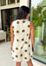 Classic polka dots never go out of style, and this charming dress from Day + Moon is the perfect blend of timeless style and feminine details. Designed with a soft cream backdrop and a rich brown polka dot print, this sleeveless dress is effortlessly chic for any occasion. The brown tie details at the top add a sweet, eye-catching touch, while the back zipper closure creates a flattering fit. 