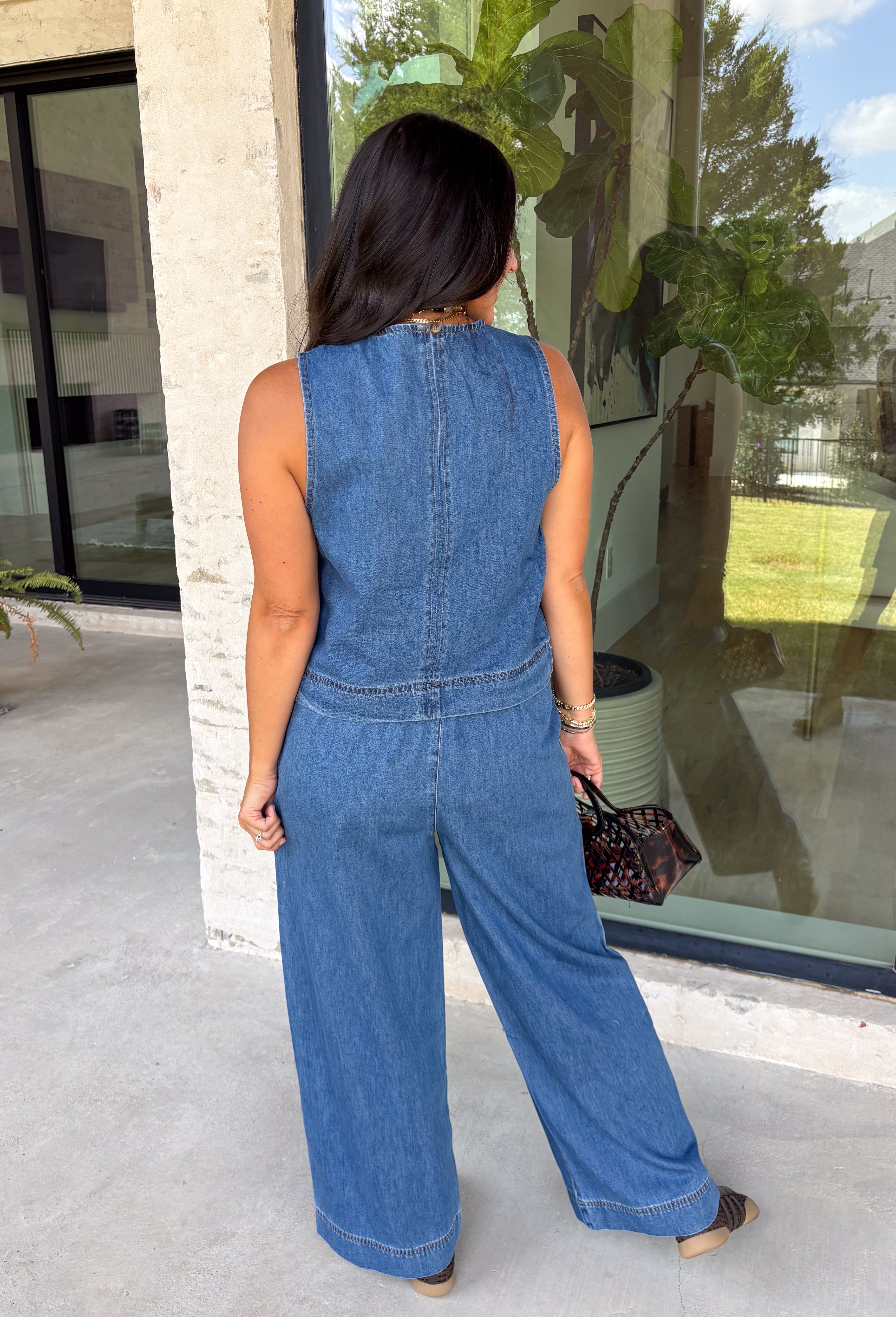 Double denim has never been easier with this matching two-piece set from Tres Bien. The sleeveless medium wash denim top features contrasting tan stitching throughout, giving the classic denim look a little extra detail. Coordinating wide leg jeans complete the set with an easy, relaxed silhouette, while the elastic waistband and adjustable self-tie detail keep the fit comfortable throughout the day. 