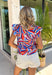 This colorful abstract print top is such a fun, statement-making piece for summer! Featuring a mix of red, white, blue, navy, and tan, it gives a subtle patriotic feel while still being easy to wear all season long. The ruffle sleeves and neckline add a soft, feminine touch, and the tie detail gives you that extra bit of styling versatility. Lightweight and breathable, it’s perfect for warm days when you want something a little elevated but still effortless. 