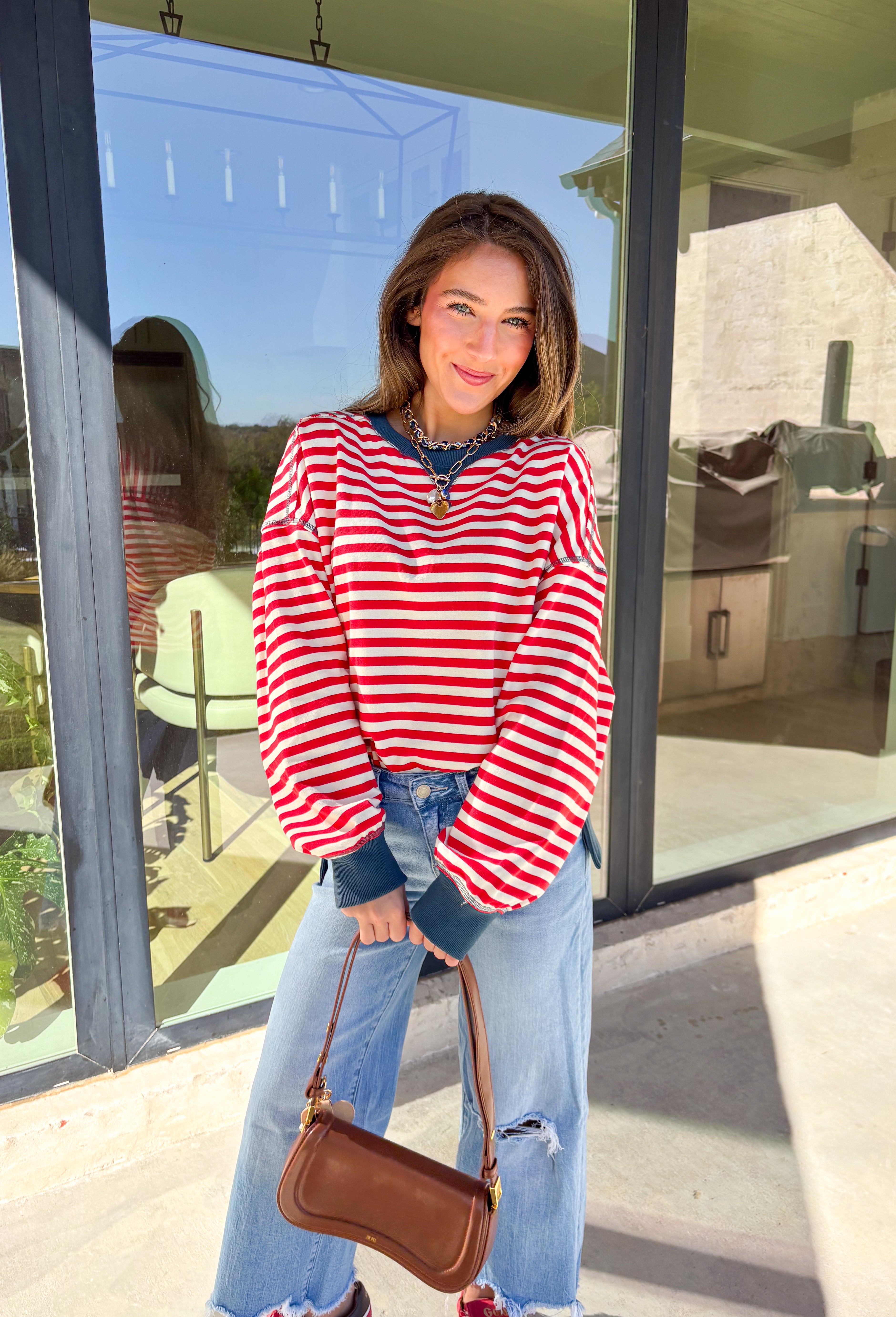 Stay cozy in classic stripes with this red and off-white pullover by New In. Designed with navy blue trim along the neckline, cuffs, and stitching, this lightweight knit brings a timeless touch to chilly days. Soft, comfortable, and easy to layer, it’s perfect for transitioning from crisp mornings to cozy evenings all winter long.