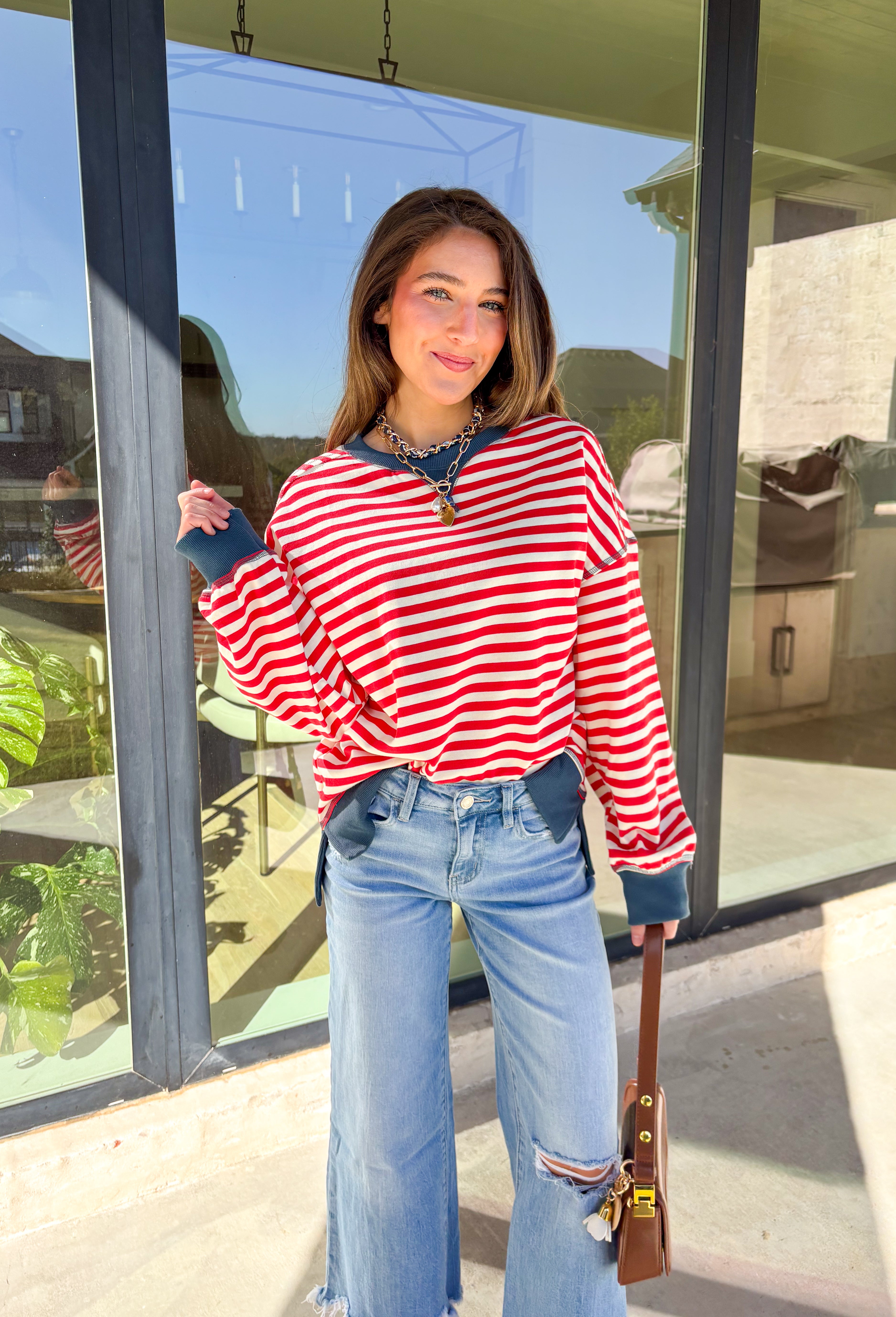 Stay cozy in classic stripes with this red and off-white pullover by New In. Designed with navy blue trim along the neckline, cuffs, and stitching, this lightweight knit brings a timeless touch to chilly days. Soft, comfortable, and easy to layer, it’s perfect for transitioning from crisp mornings to cozy evenings all winter long.