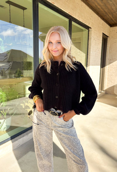 Keep it classic and cozy with this black knit button-down cardigan by Hyfve. The soft, medium-weight knit makes it perfect for layering through the seasons, while the timeless button-down design keeps it versatile for any occasion. Whether worn open over a tee or buttoned up with jeans, this cardigan is an easy go-to for effortless colder weather styling.