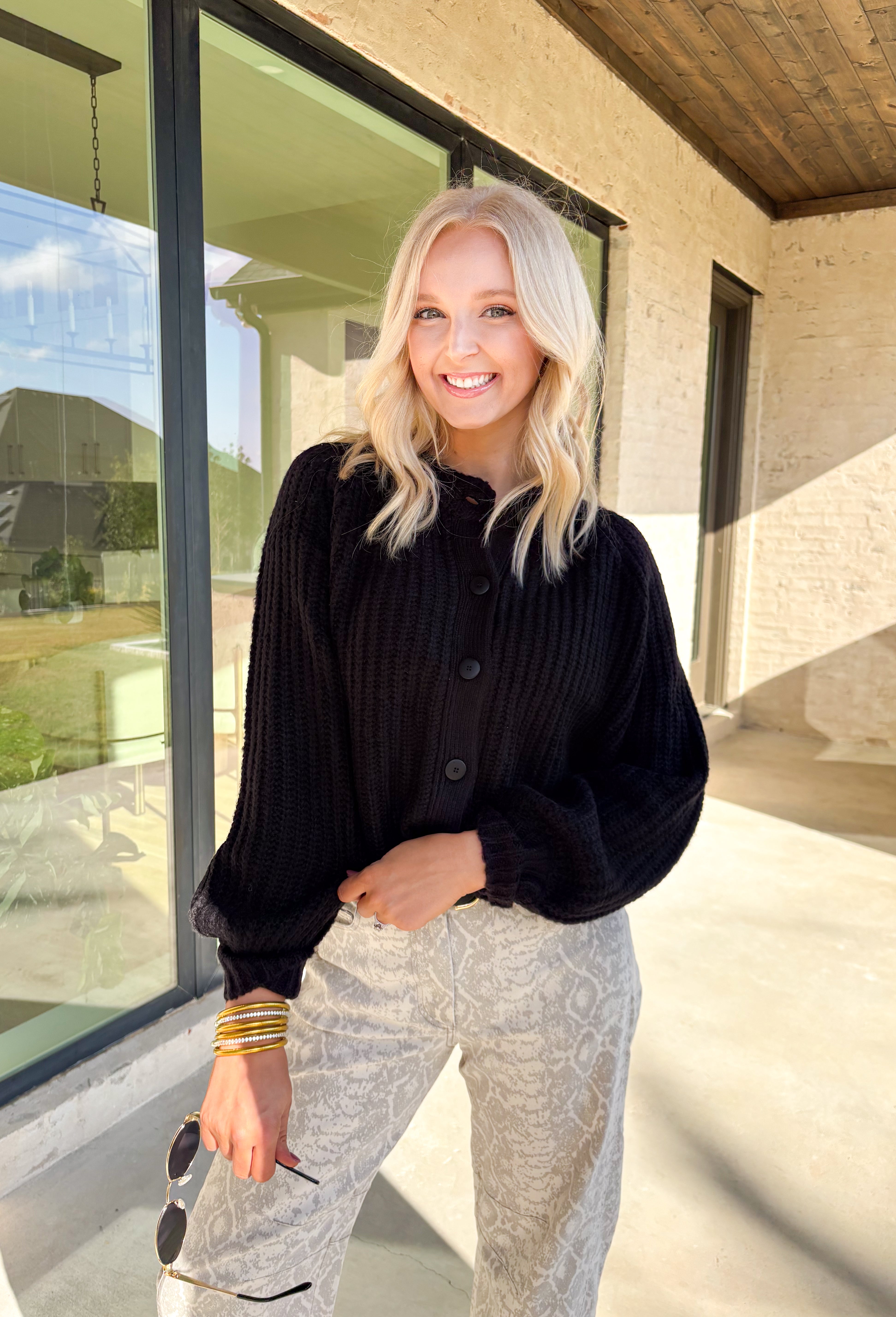 Keep it classic and cozy with this black knit button-down cardigan by Hyfve. The soft, medium-weight knit makes it perfect for layering through the seasons, while the timeless button-down design keeps it versatile for any occasion. Whether worn open over a tee or buttoned up with jeans, this cardigan is an easy go-to for effortless colder weather styling.