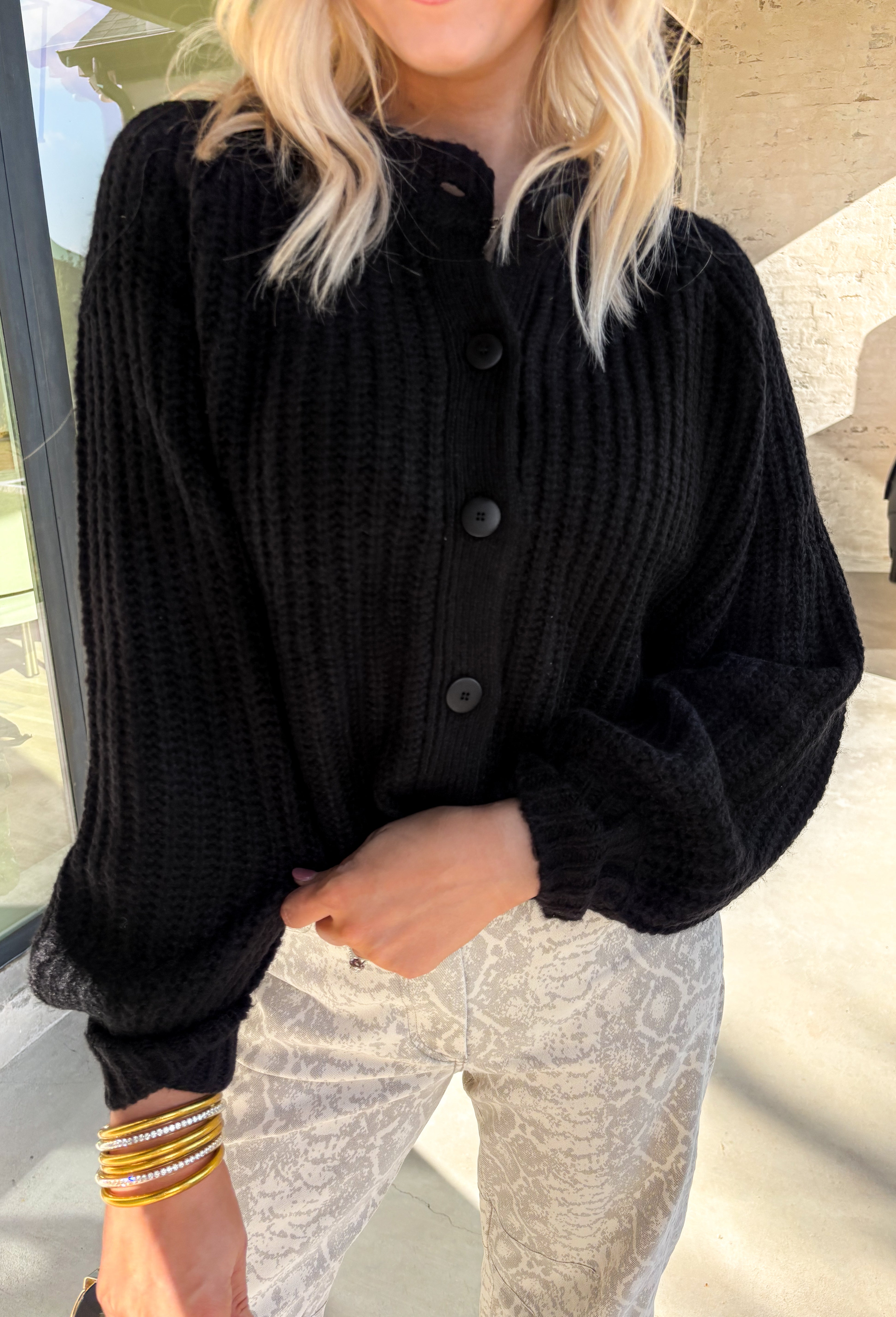 Keep it classic and cozy with this black knit button-down cardigan by Hyfve. The soft, medium-weight knit makes it perfect for layering through the seasons, while the timeless button-down design keeps it versatile for any occasion. Whether worn open over a tee or buttoned up with jeans, this cardigan is an easy go-to for effortless colder weather styling.