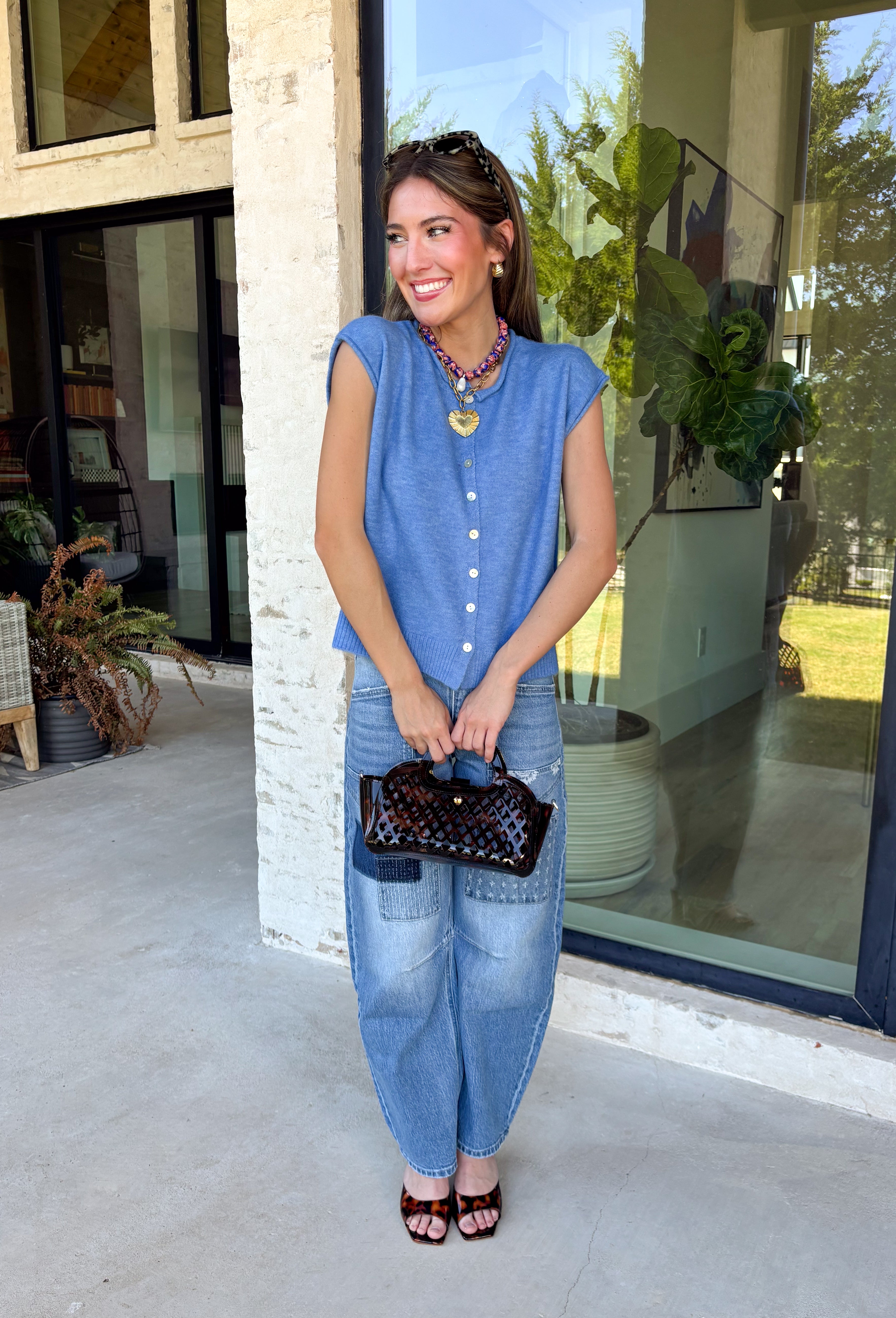 Layering season calls for pieces that can keep up with changing temperatures, and this blue sleeveless cardigan from Double Zero is ready for just that. The cozy knit brings plenty of texture and warmth, while the sleeveless design makes it easy to wear alone on milder days or layer over a long sleeve top as winter gets closer. A button-down front gives you multiple ways to style it, and the ribbed hem adds a classic sweater finish.