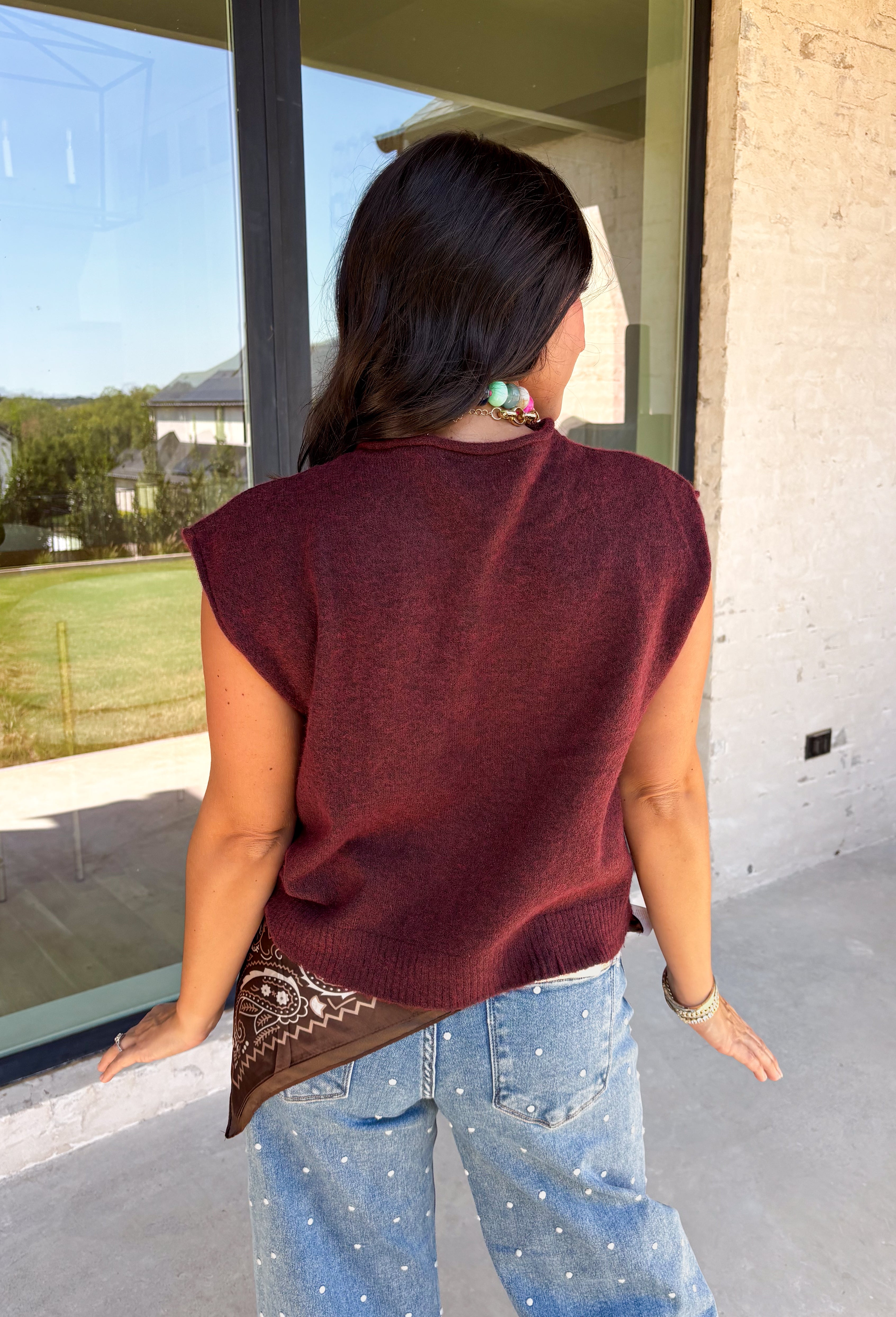 Layering season calls for pieces that can keep up with changing temperatures, and this dark cherry sleeveless cardigan from Double Zero is ready for just that. The cozy knit brings plenty of texture and warmth, while the sleeveless design makes it easy to wear alone on milder days or layer over a long sleeve top as winter gets closer. A button-down front gives you multiple ways to style it, and the ribbed hem adds a classic sweater finish. 