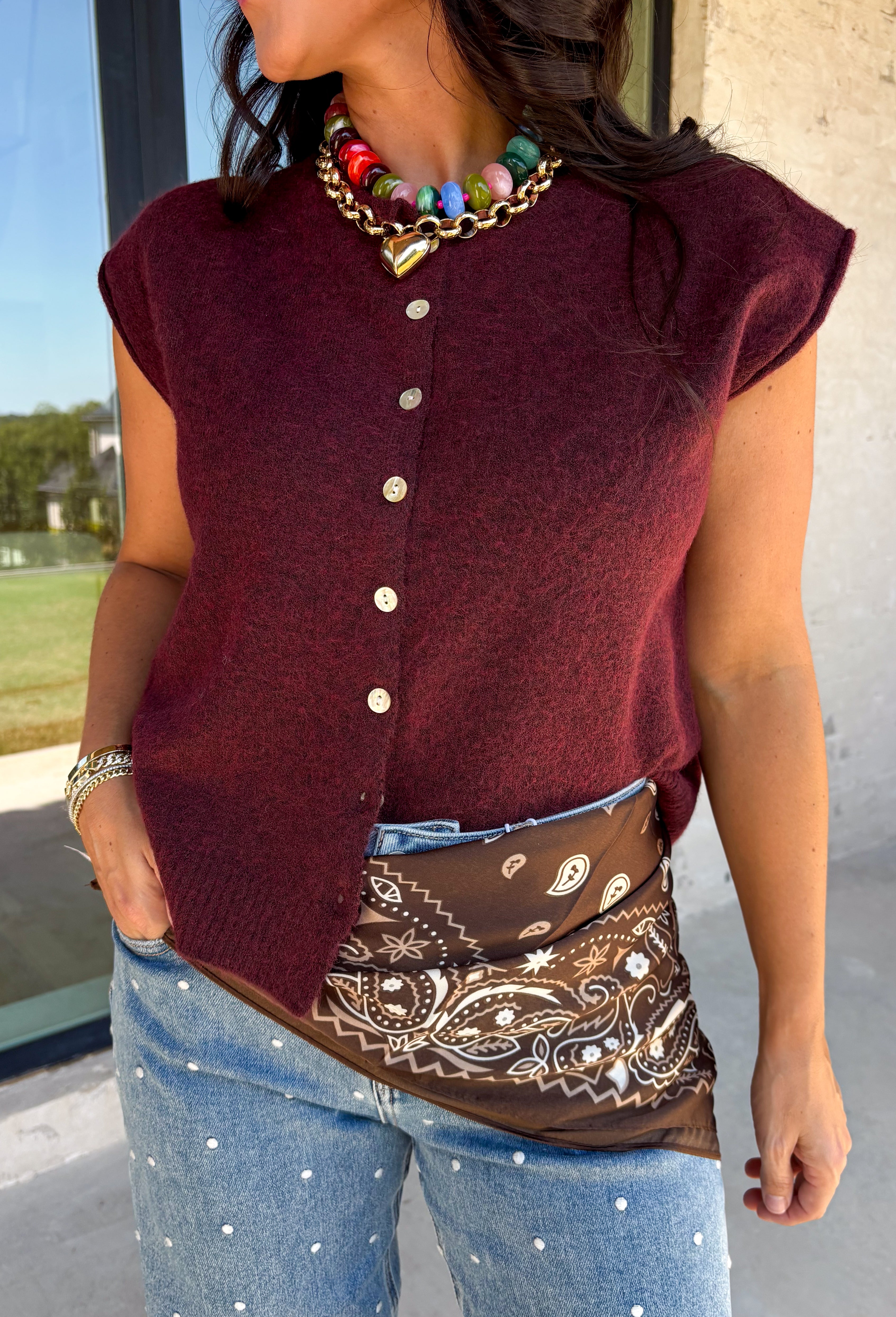Layering season calls for pieces that can keep up with changing temperatures, and this dark cherry sleeveless cardigan from Double Zero is ready for just that. The cozy knit brings plenty of texture and warmth, while the sleeveless design makes it easy to wear alone on milder days or layer over a long sleeve top as winter gets closer. A button-down front gives you multiple ways to style it, and the ribbed hem adds a classic sweater finish. 