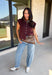Layering season calls for pieces that can keep up with changing temperatures, and this dark cherry sleeveless cardigan from Double Zero is ready for just that. The cozy knit brings plenty of texture and warmth, while the sleeveless design makes it easy to wear alone on milder days or layer over a long sleeve top as winter gets closer. A button-down front gives you multiple ways to style it, and the ribbed hem adds a classic sweater finish. 