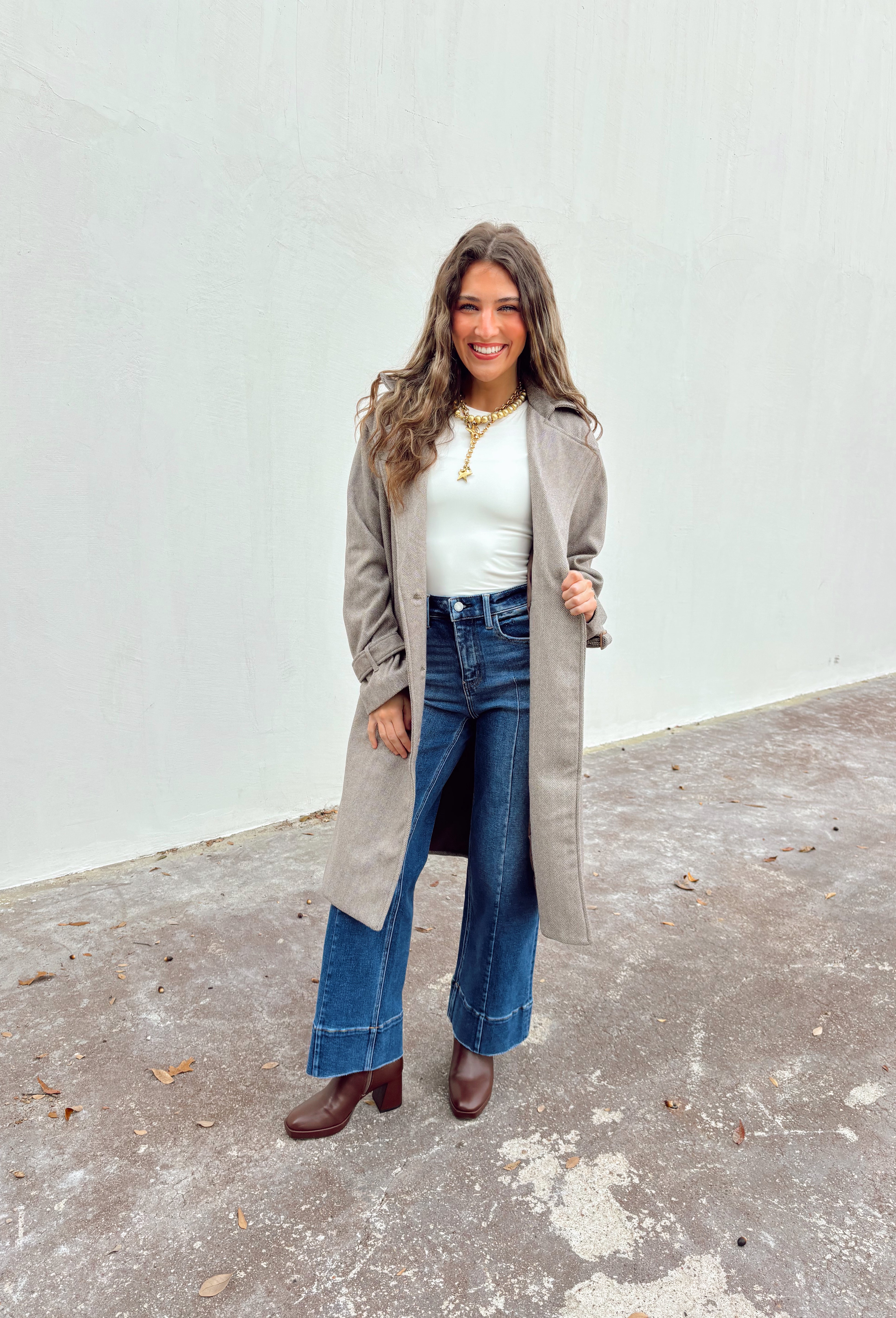 Timeless and tailored, this brown mini houndstooth coat by Haute Monde is a must-have for the chilly season. Featuring a collared neckline and button-down front, this soft and cozy coat brings effortless polish to any winter look. Its classic pattern and warm, textured feel make it a go-to piece for layering over sweaters, dresses, or denim all season long.