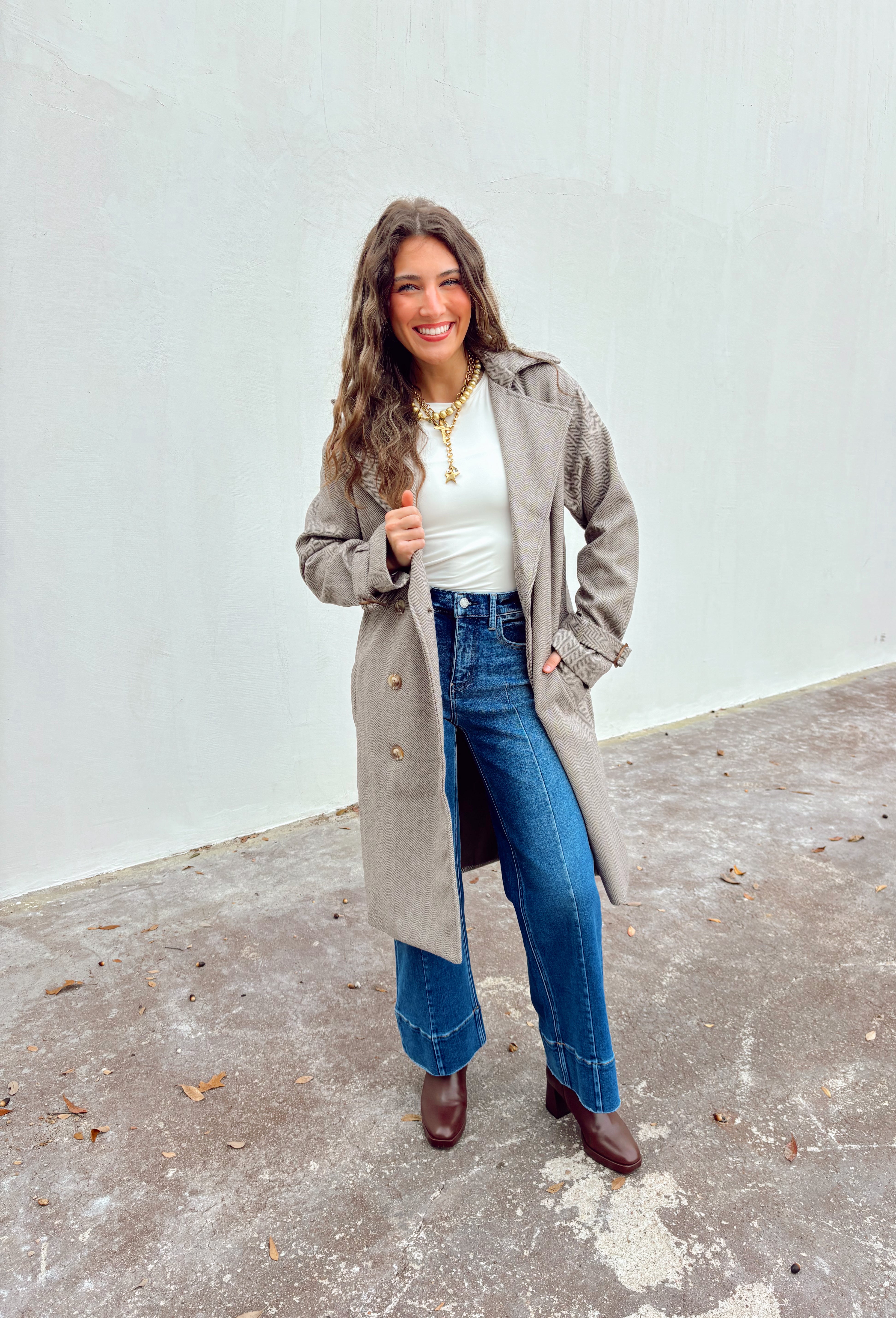 Timeless and tailored, this brown mini houndstooth coat by Haute Monde is a must-have for the chilly season. Featuring a collared neckline and button-down front, this soft and cozy coat brings effortless polish to any winter look. Its classic pattern and warm, textured feel make it a go-to piece for layering over sweaters, dresses, or denim all season long.